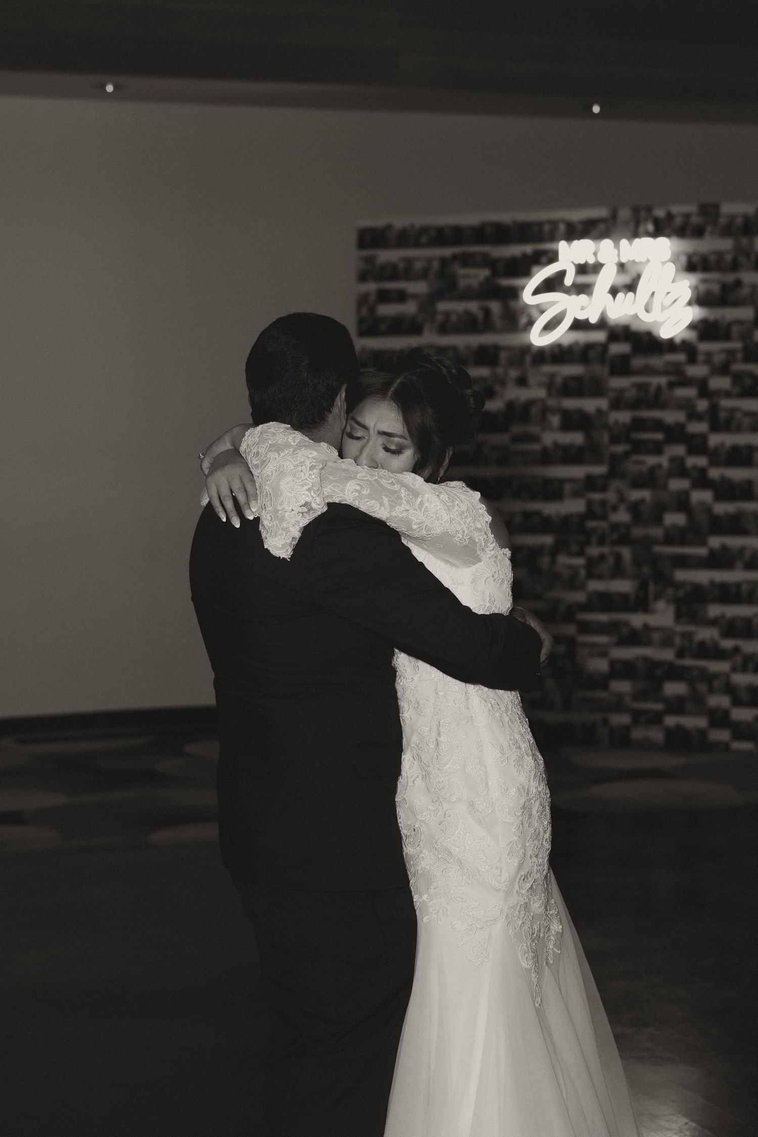 A romantic black and white photo captures a couple's intimate first dance at their wedding reception.