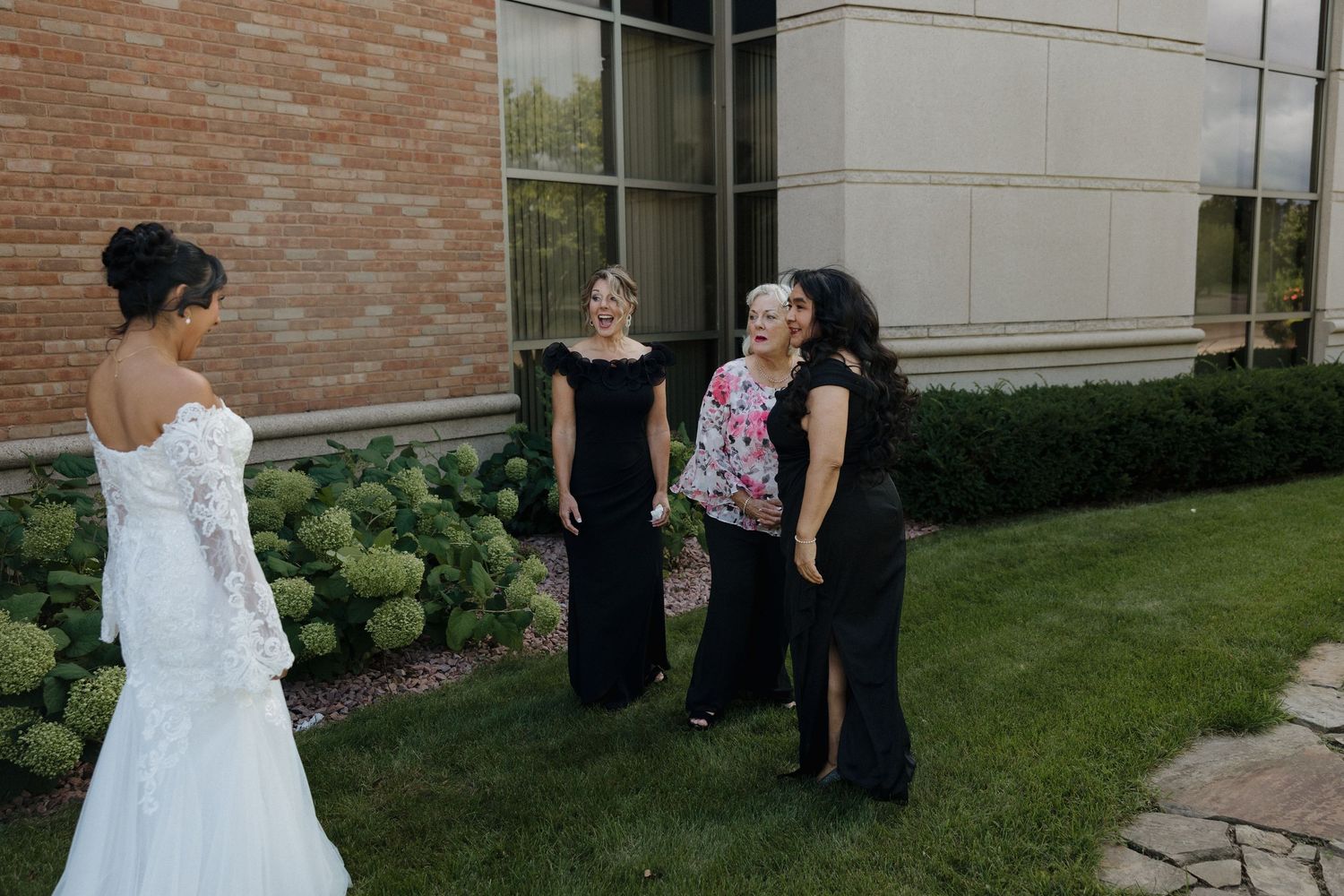 A romantic first look sequence between a couple in wedding attire outside a brick building.