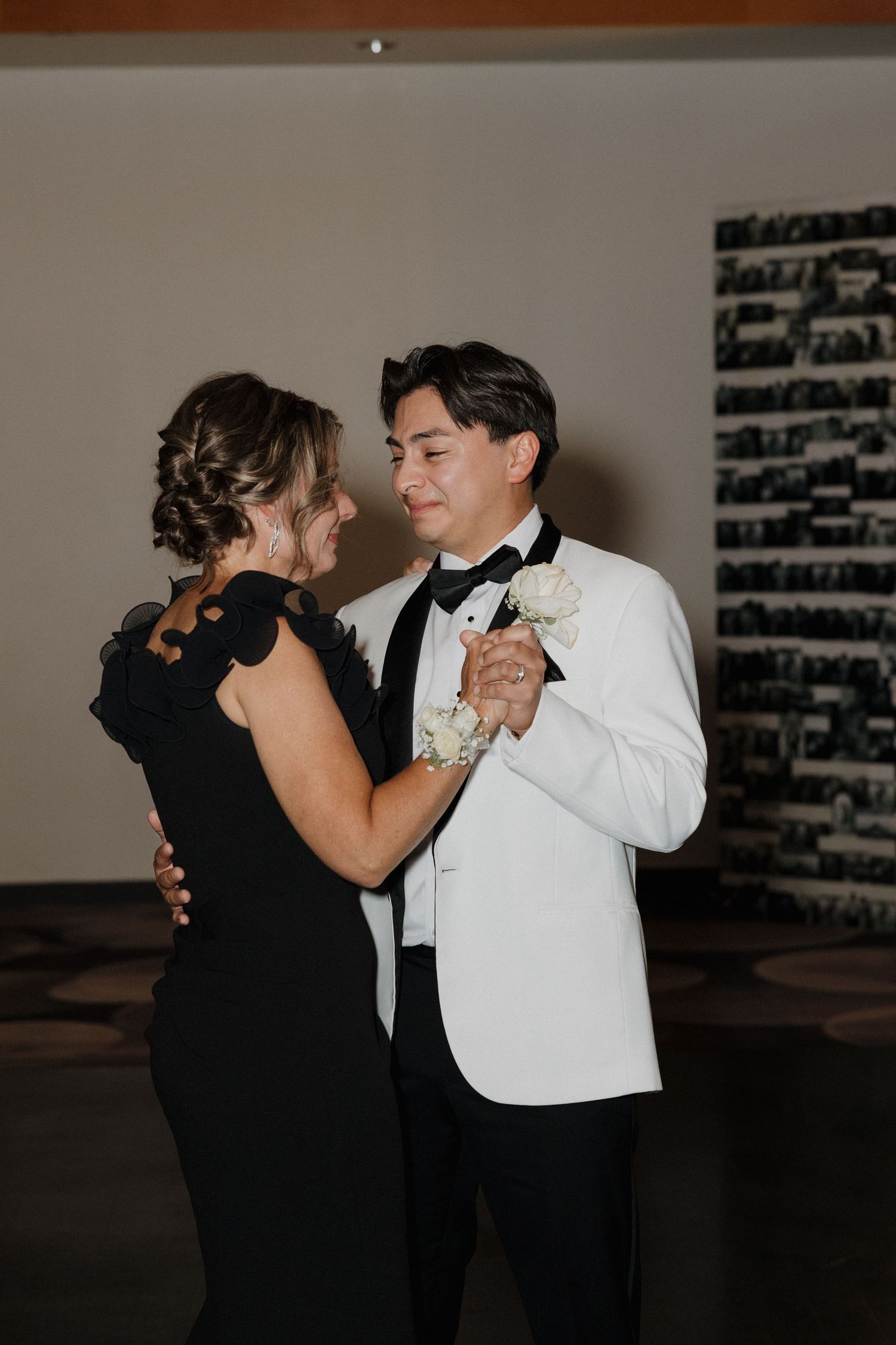 A couple shares an intimate dance together in formal black and white attire.