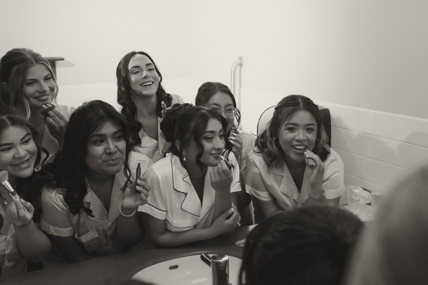 A group of friends pose together while sitting and laughing during a celebration.