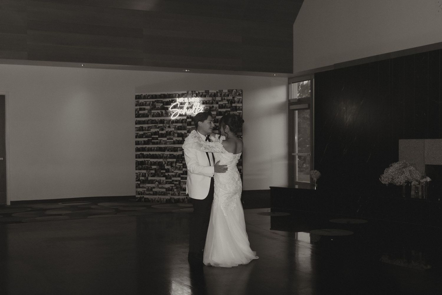 Black and white photos displayed in a filmstrip-style layout showing romantic wedding moments in an indoor venue.