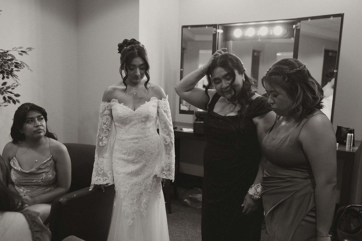 Wedding party members gather in a room getting ready before the ceremony.