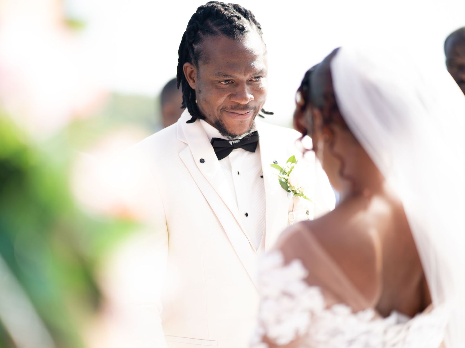 A happy couple shares a joyful moment during their outdoor wedding ceremony in formal attire.