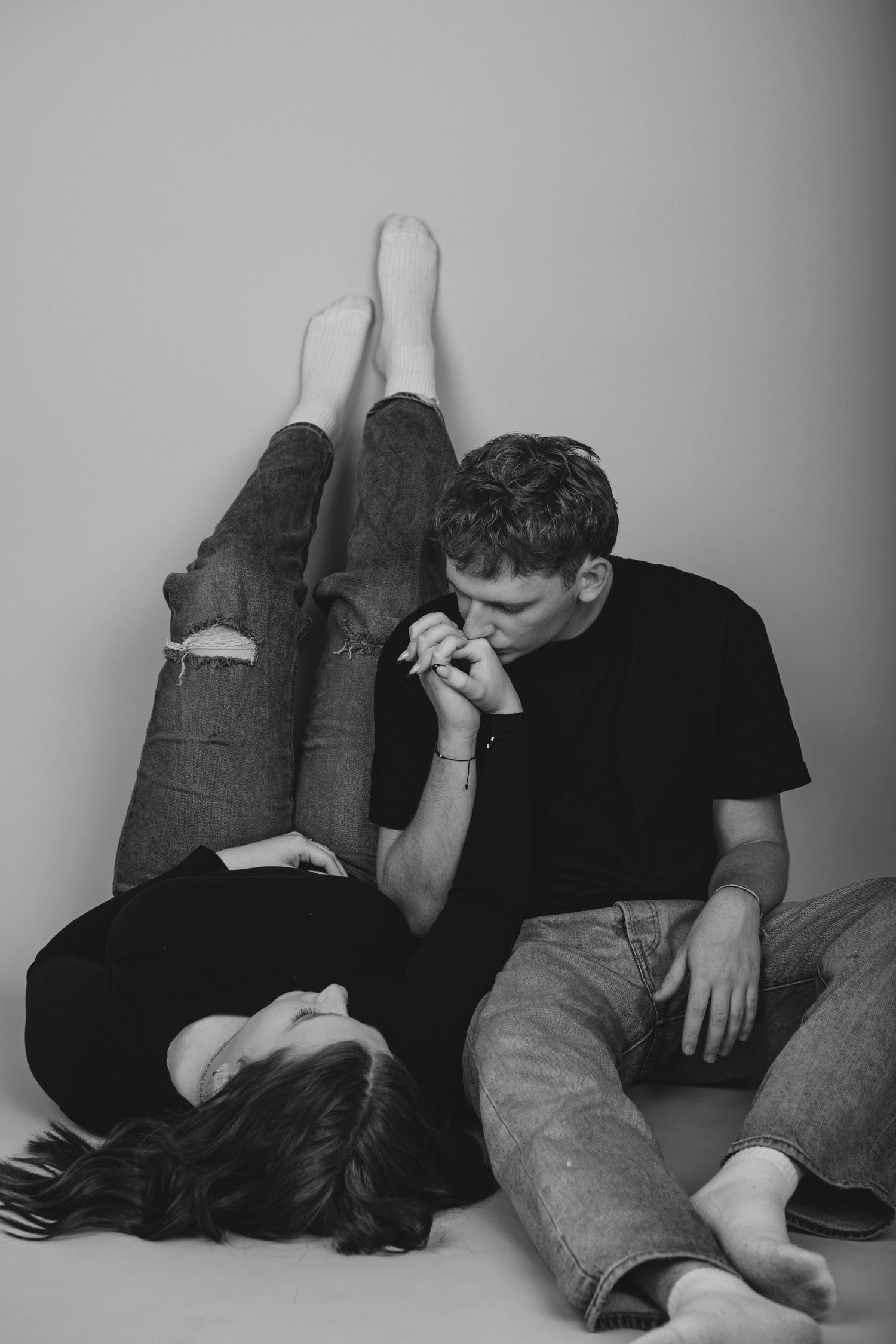 Intimate black and white portrait of two people in casual clothing.