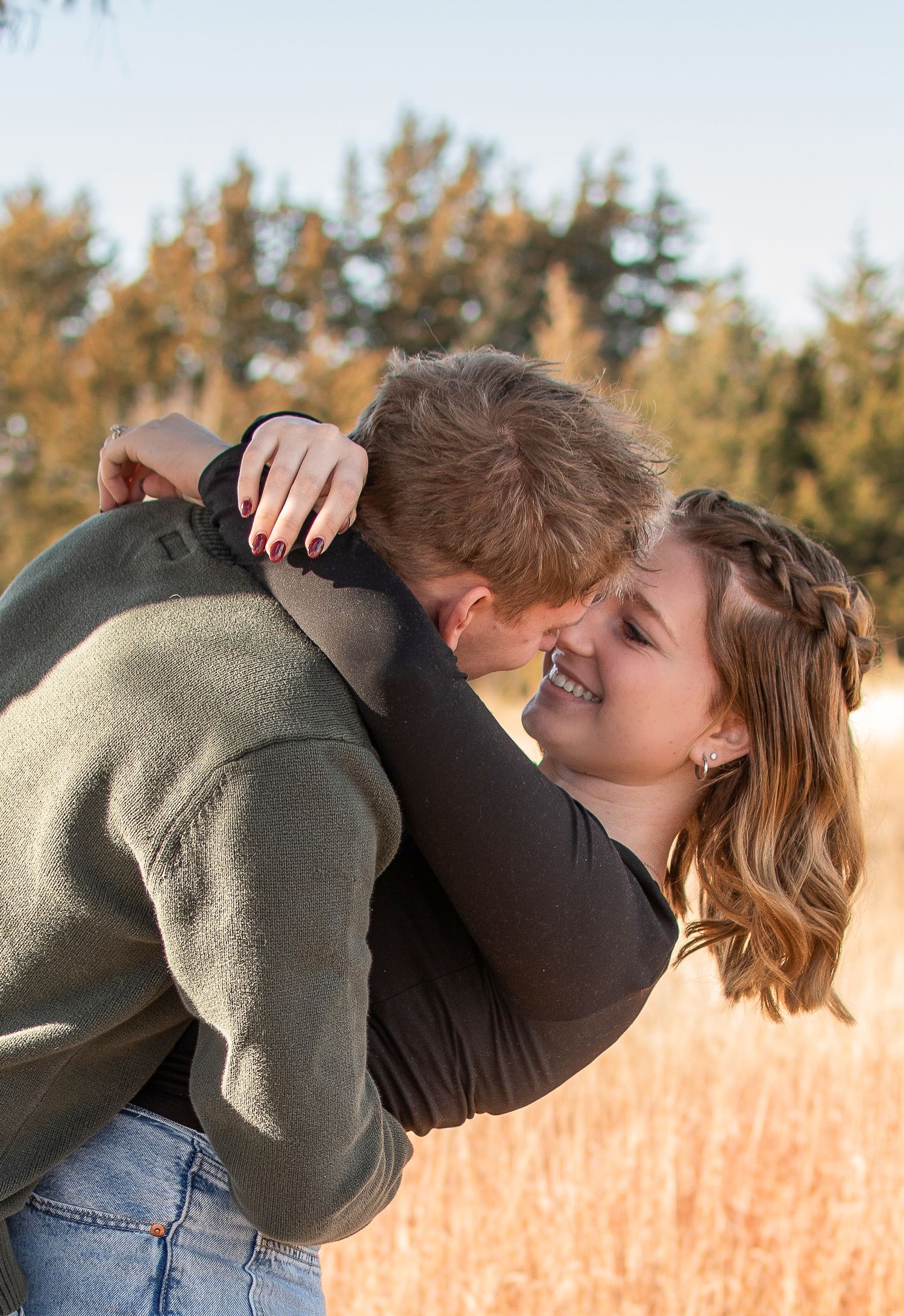 Romantic couple embracing in a golden field during sunset.