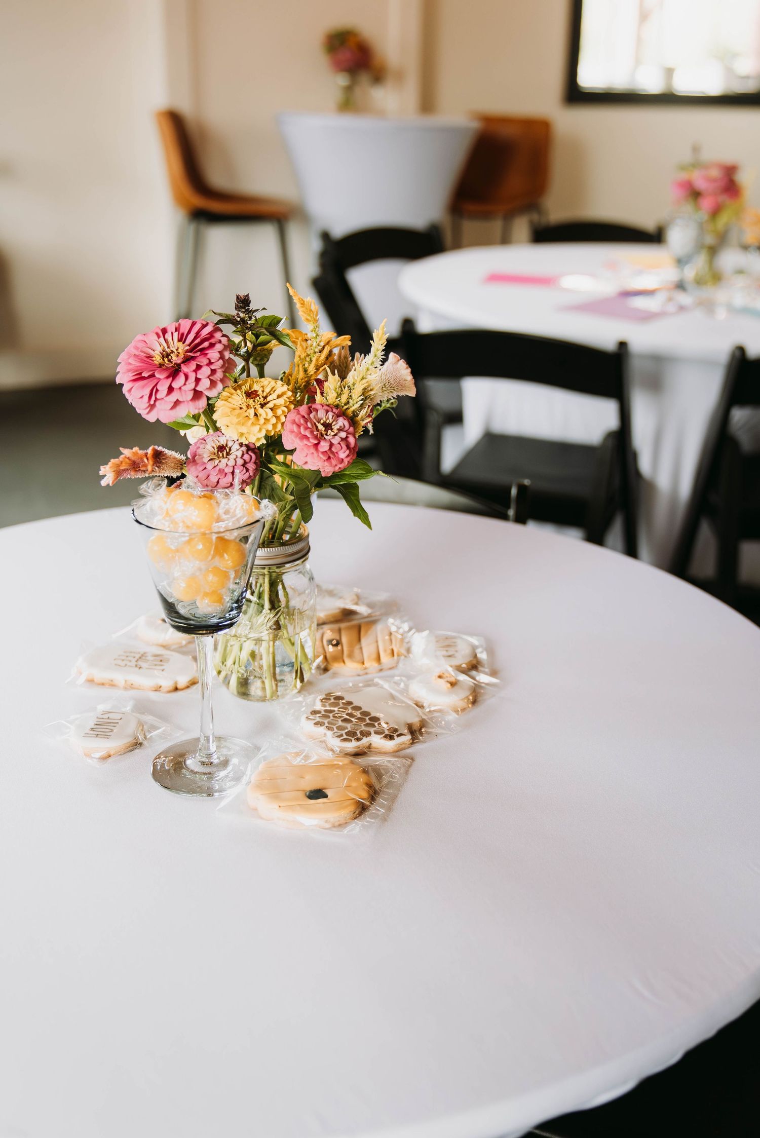 Elegant table settings with pink floral centerpieces and white linens for a special event.