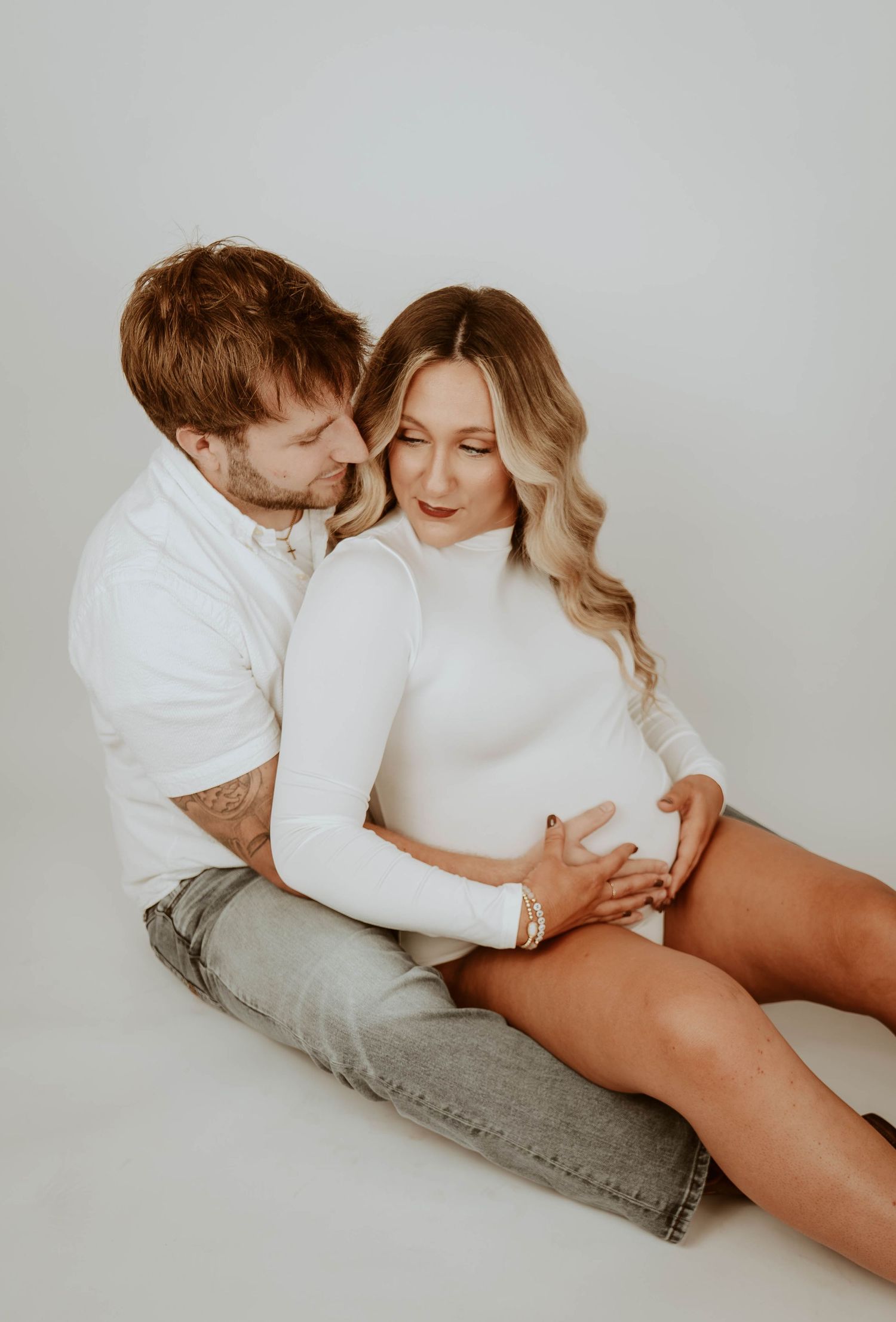 Intimate couples boudoir photo session against minimal white background.