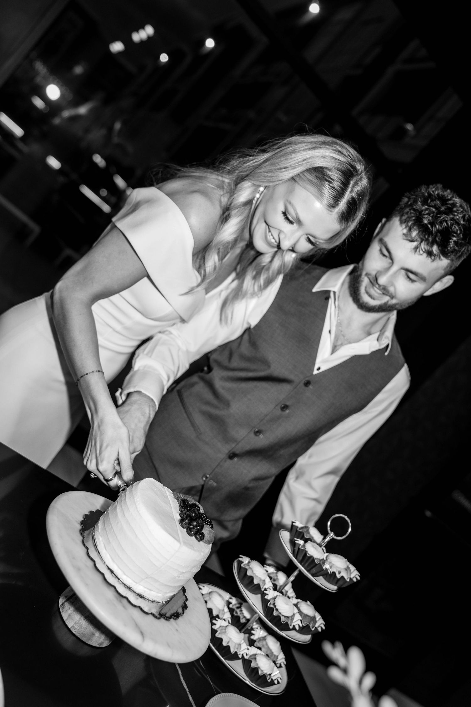 Black and white photo of couple dancing together at reception party.