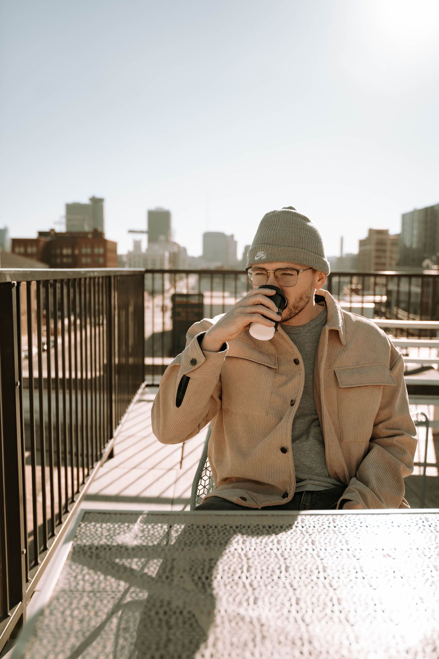 Person taking photos with camera against urban rooftop backdrop.