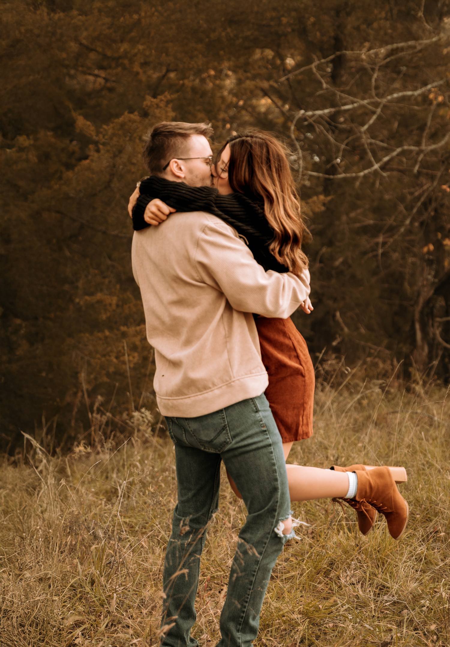 Dancing and twirling together in a golden autumn field during sunset.