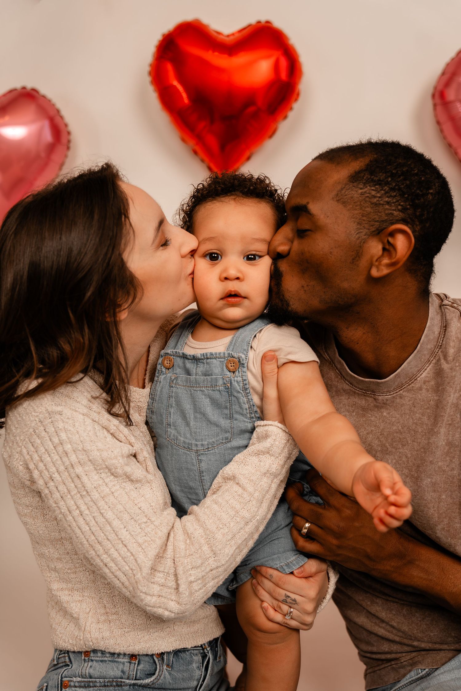 Sweet family moment with heart-shaped balloons in the background.