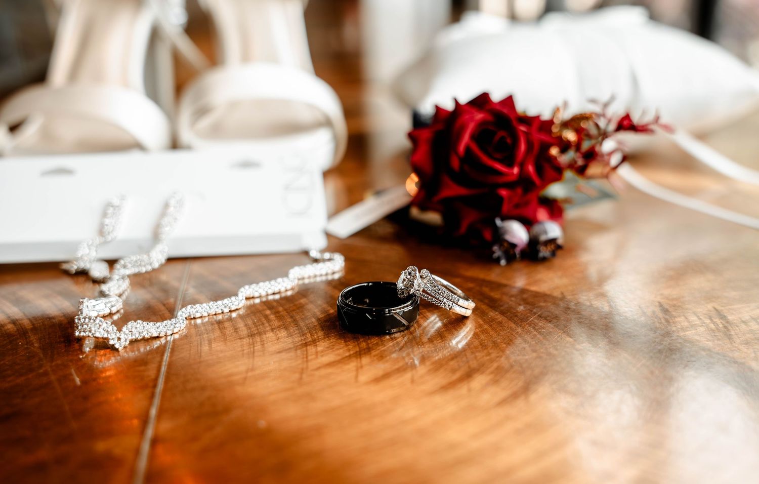 Wedding details and accessories artistically arranged on wooden surface.