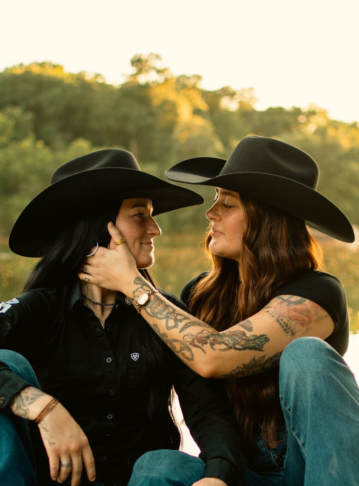 A romantic western-themed photoshoot at sunset with cowboy hats and denim outfits.