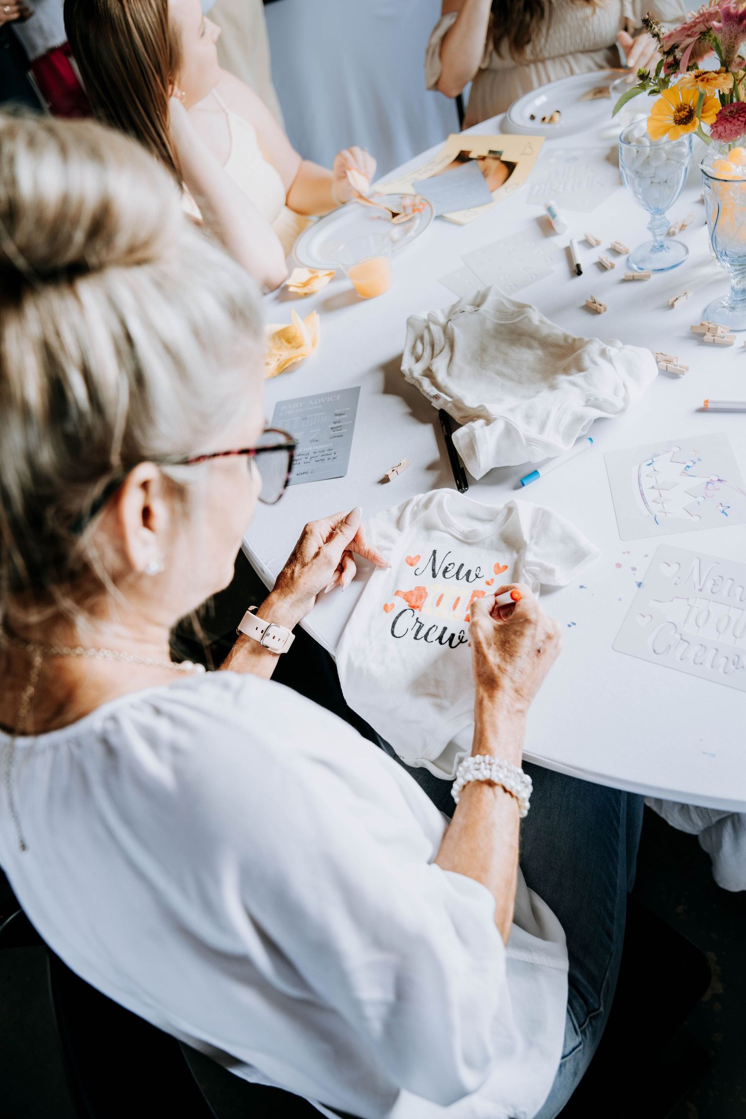 Participants writing and working on papers at white-clothed tables during a workshop.