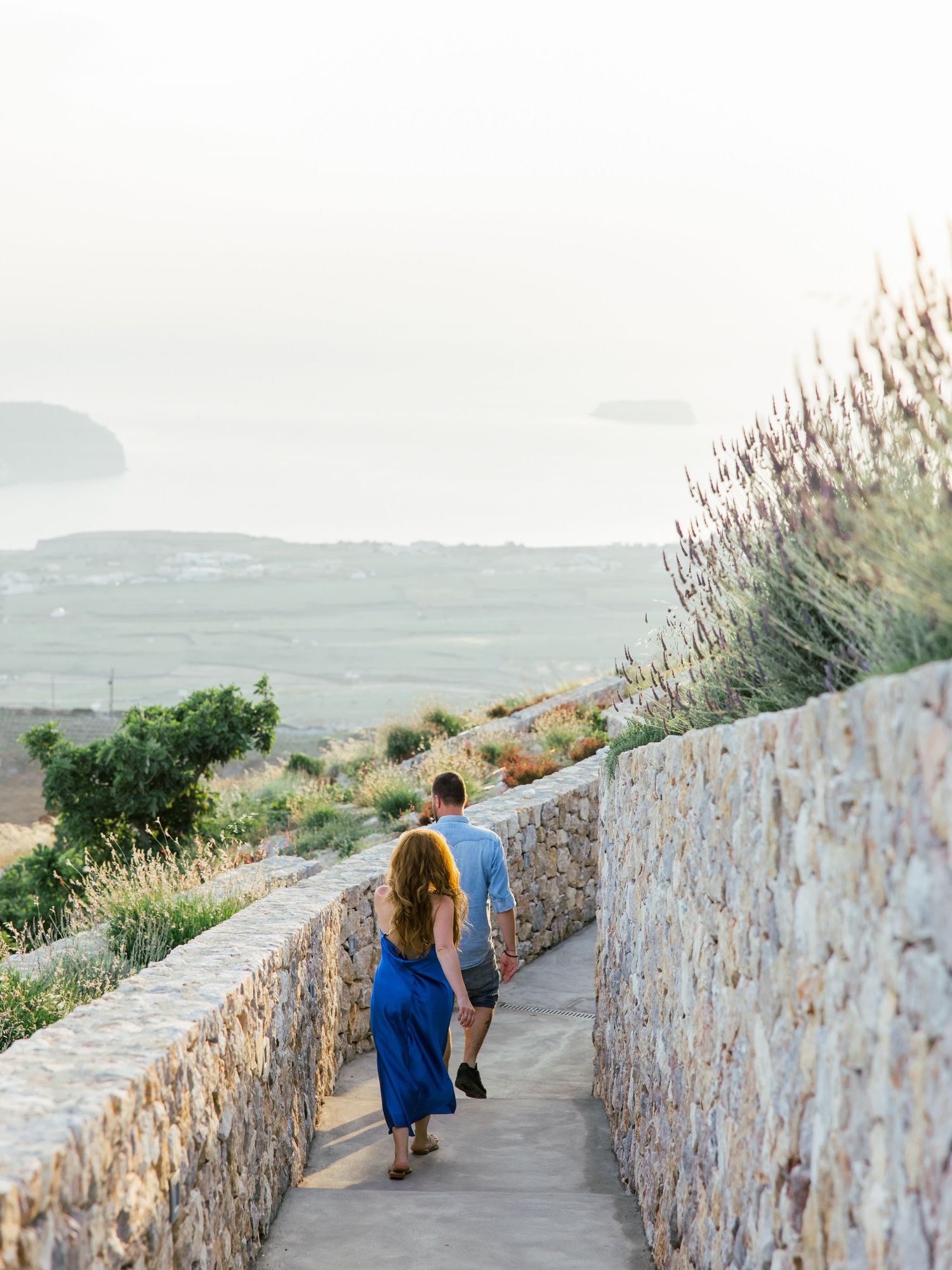 A stone pathway along a coastal cliff with scenic ocean views in Santorini.