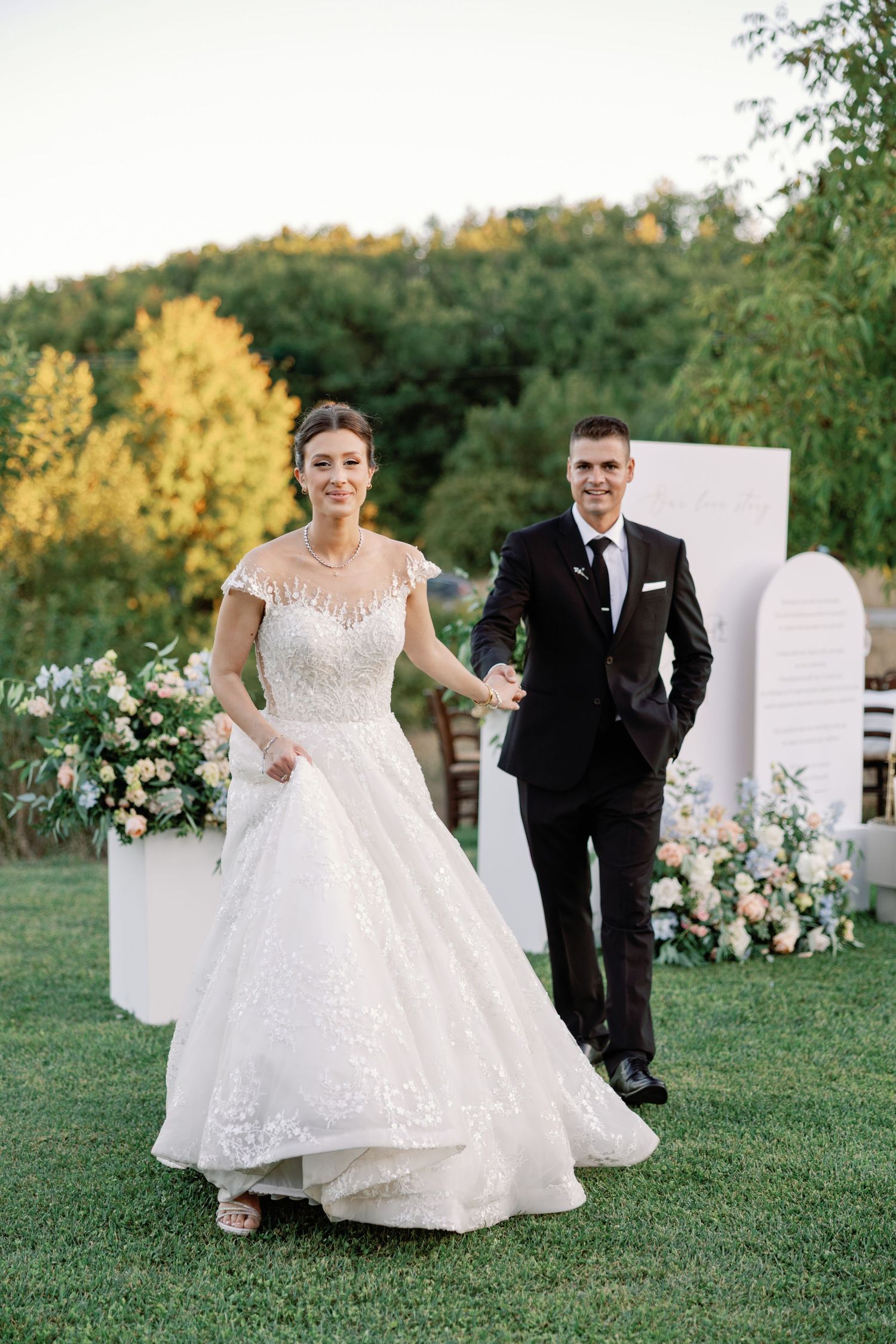 Wedding ceremony setup with white decor panels and floral arrangements in an outdoor garden setting.