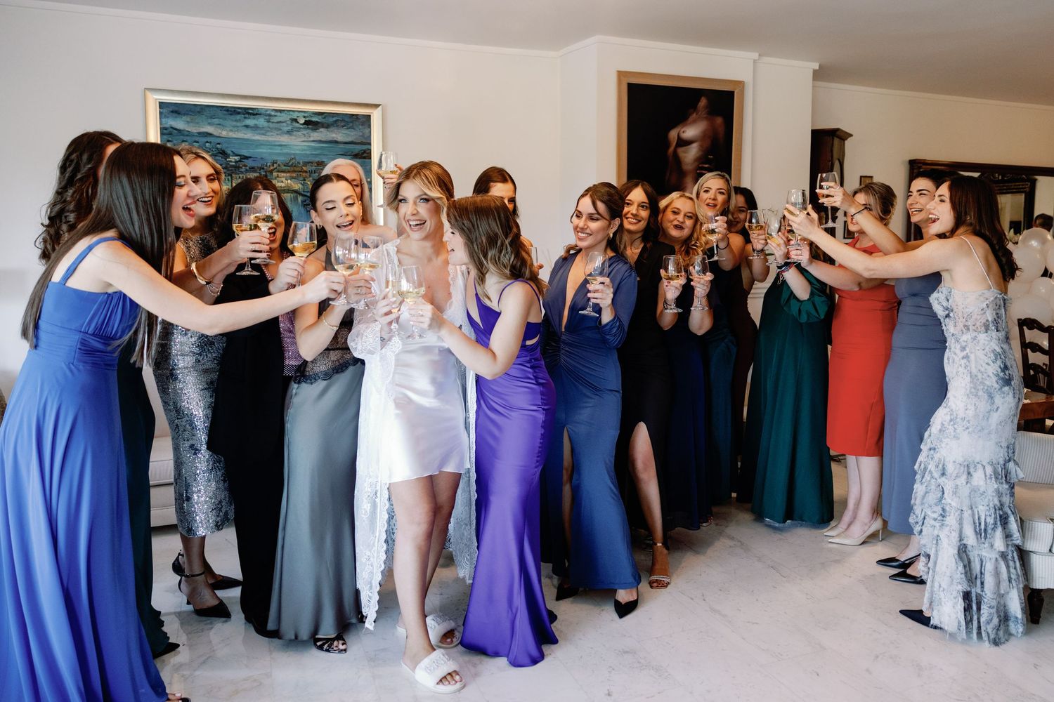 Wedding party members in blue and purple dresses lined up for a group photo.