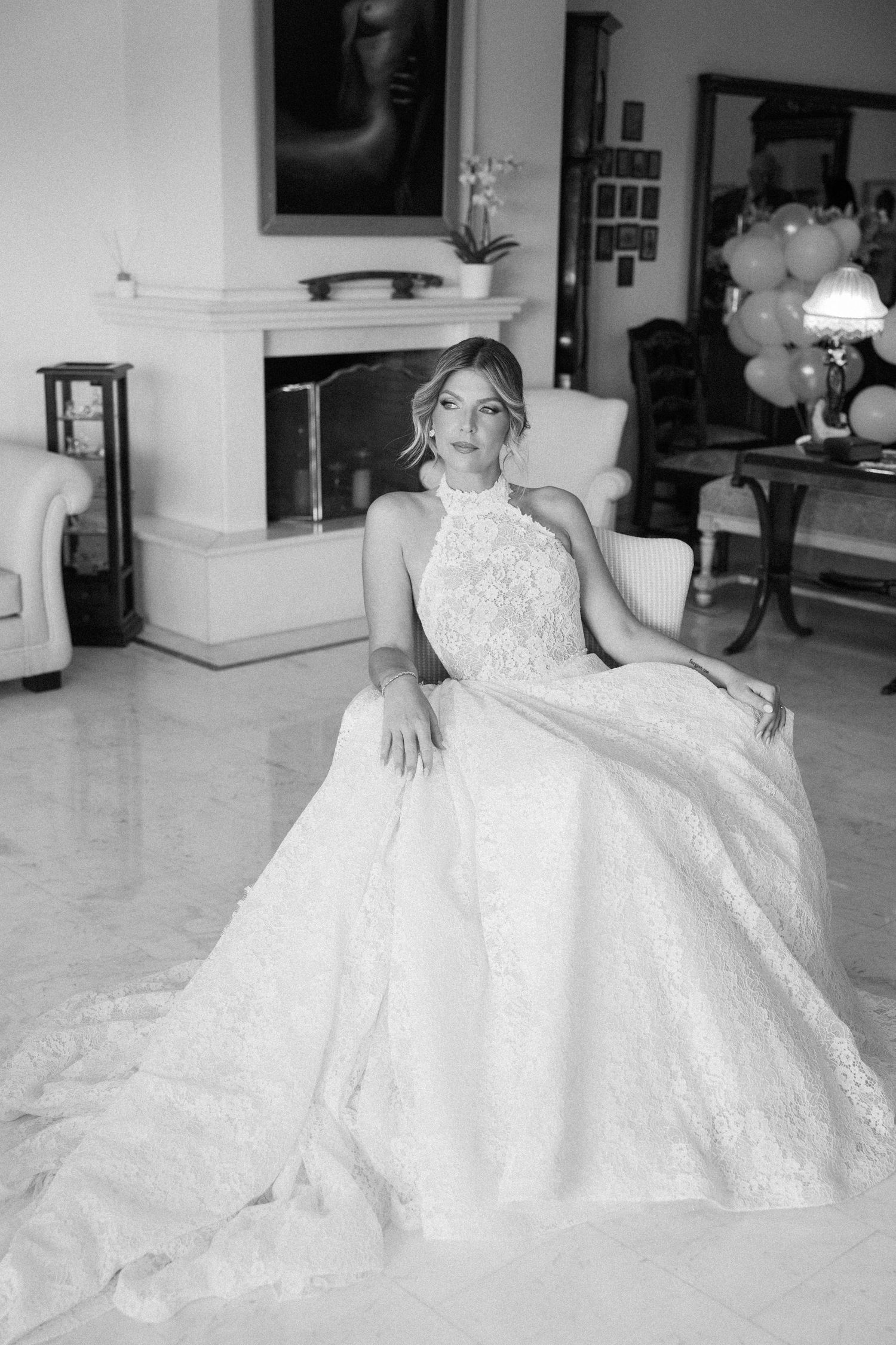 Elegant white ball gown wedding dress with intricate lace details spread across a light-colored floor.