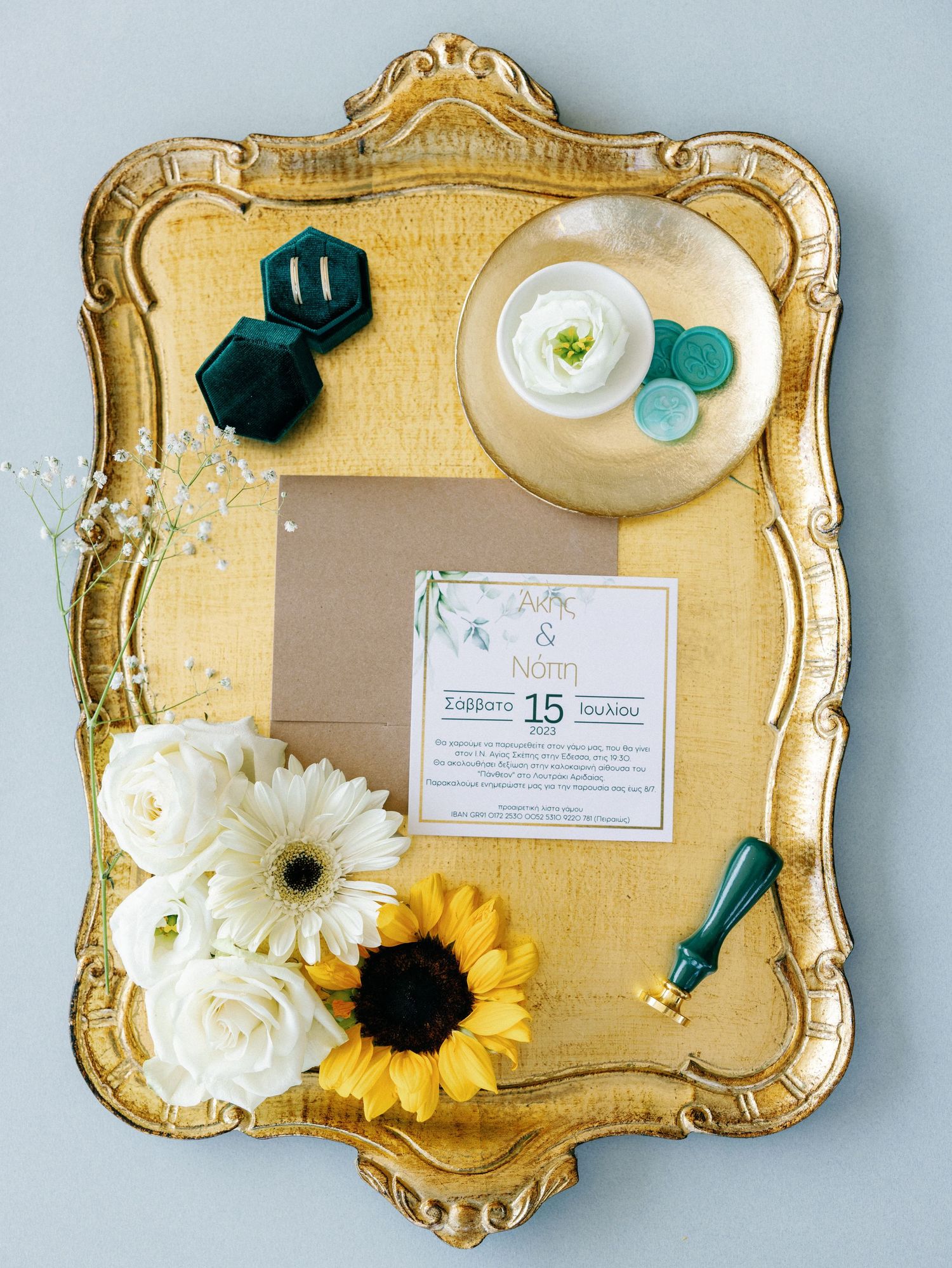 Elegant gold vintage tray with white and yellow flowers, wedding stationery, and decorative elements.