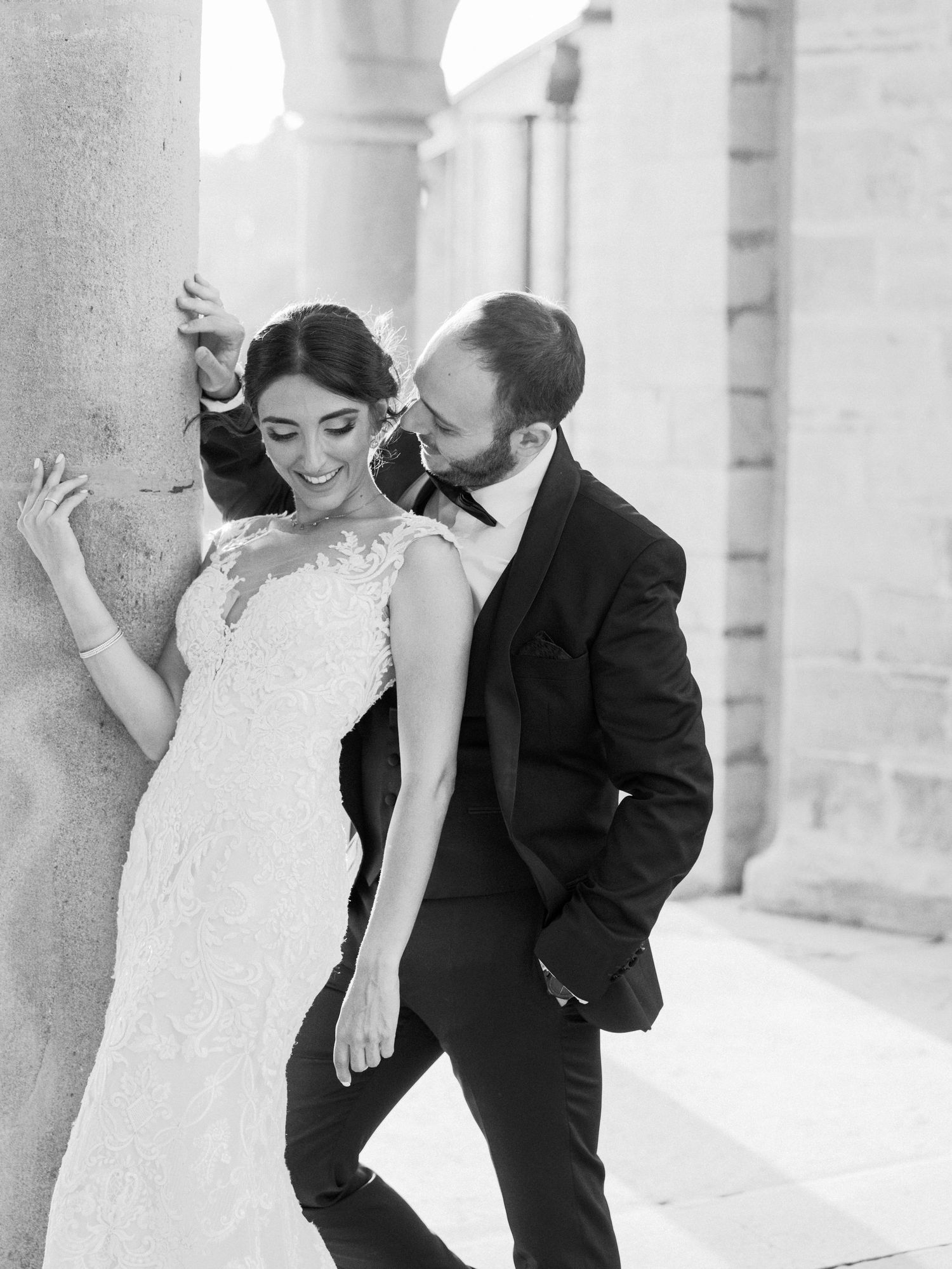A romantic black and white moment captured under stone archways.