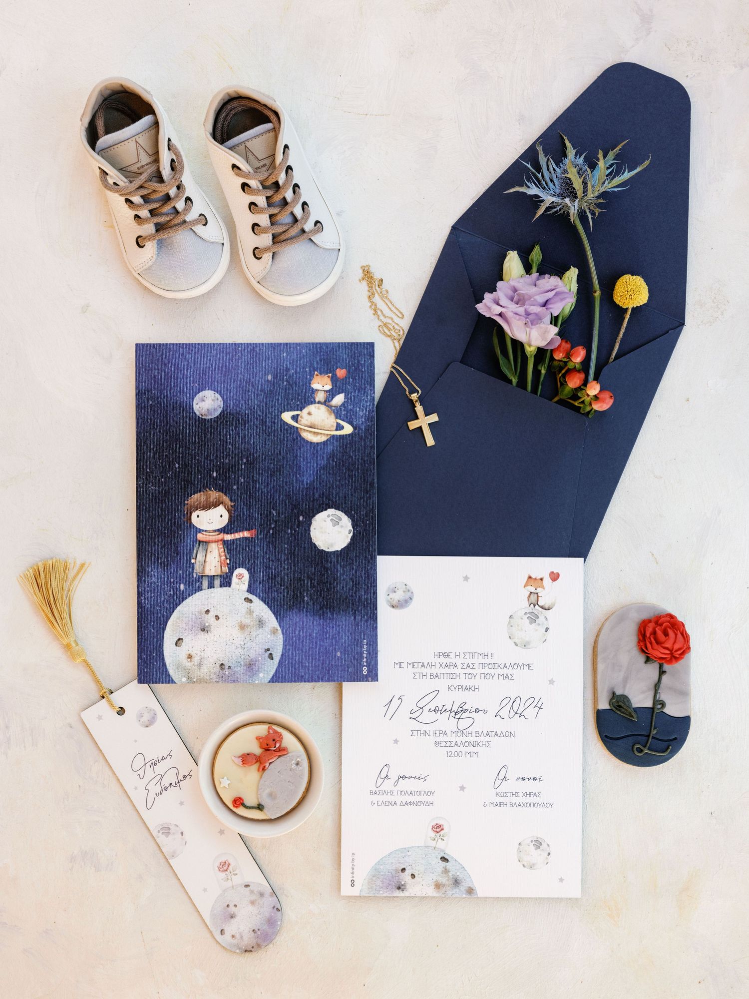 Navy blue wedding stationery suite with floral accents and delicate details laid out on white surface with gold elements.