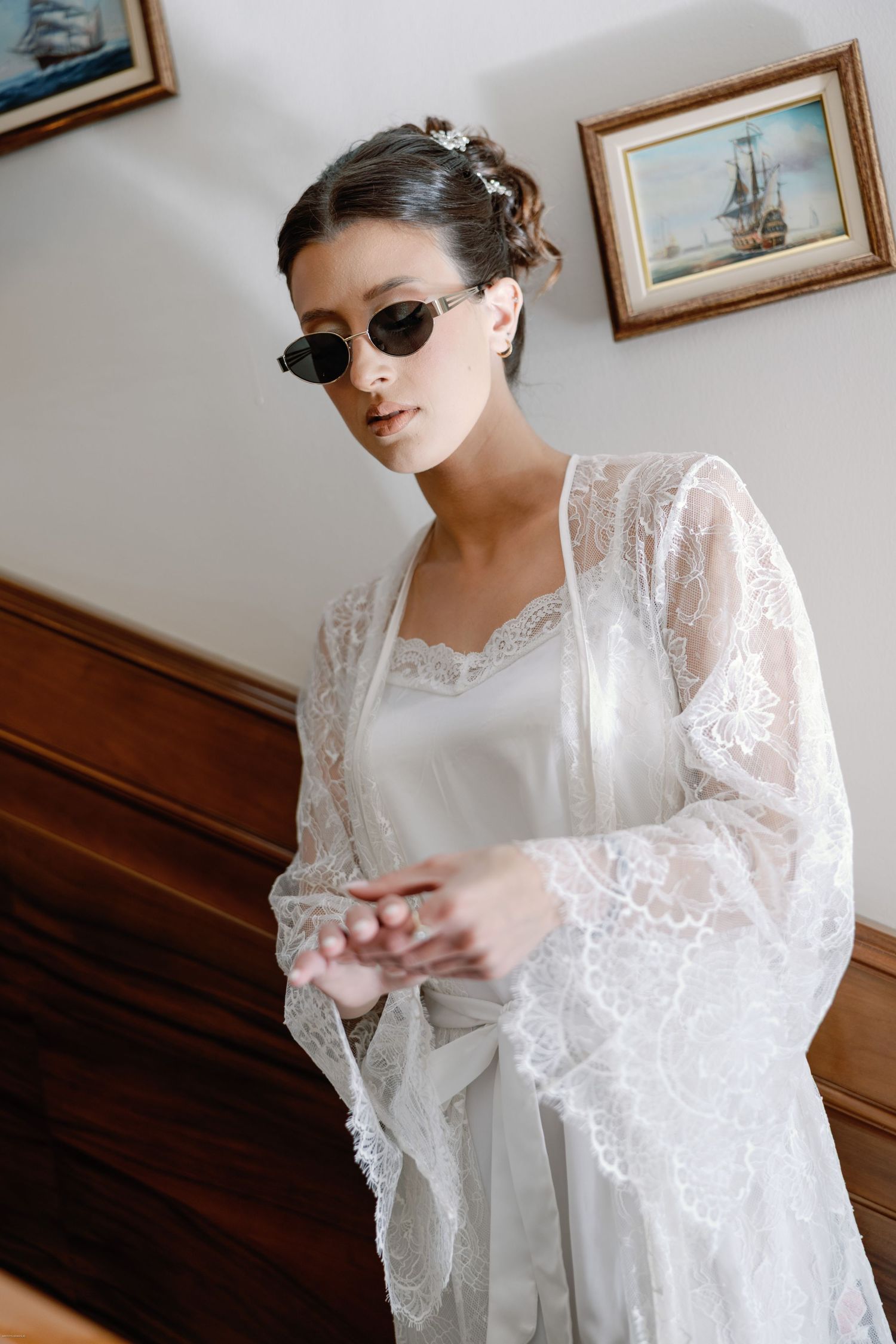 Woman wearing sunglasses and lace robe in vintage-inspired bridal portrait.