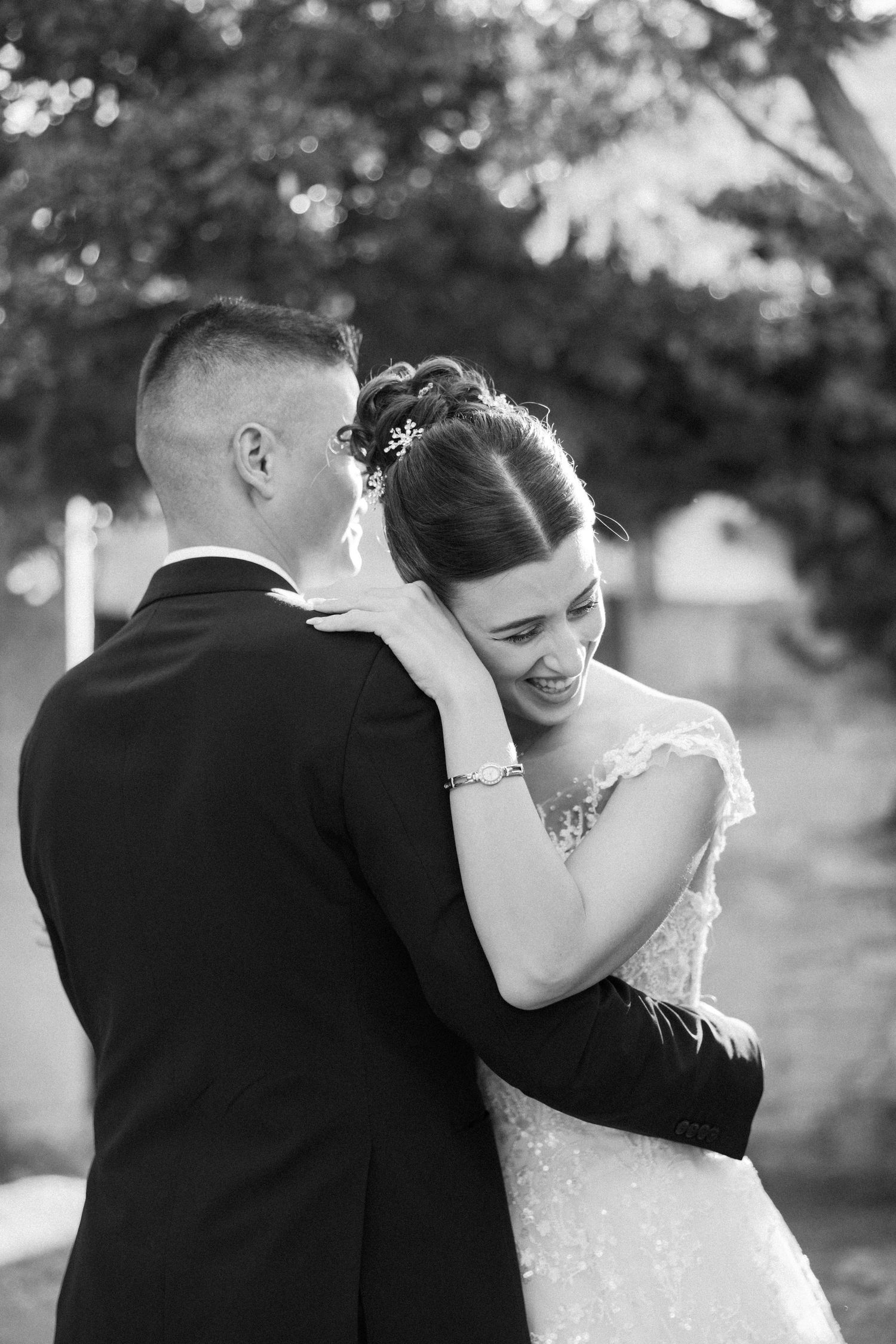 Black and white wedding photos capture intimate moments between newlyweds in an outdoor setting.