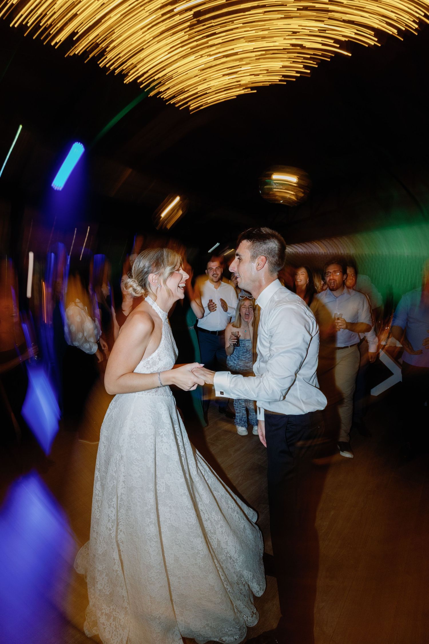 Wedding reception dance floor with dramatic lighting and couples dancing in formal attire.
