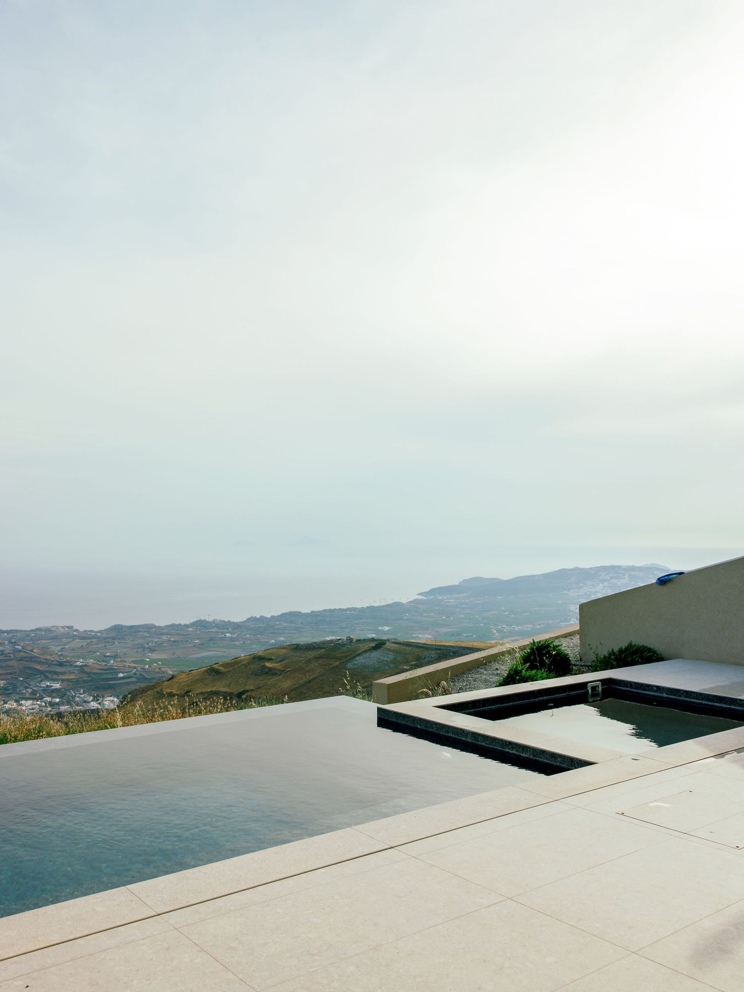 Infinity pool overlooking coastal mountains and ocean views from luxury property.