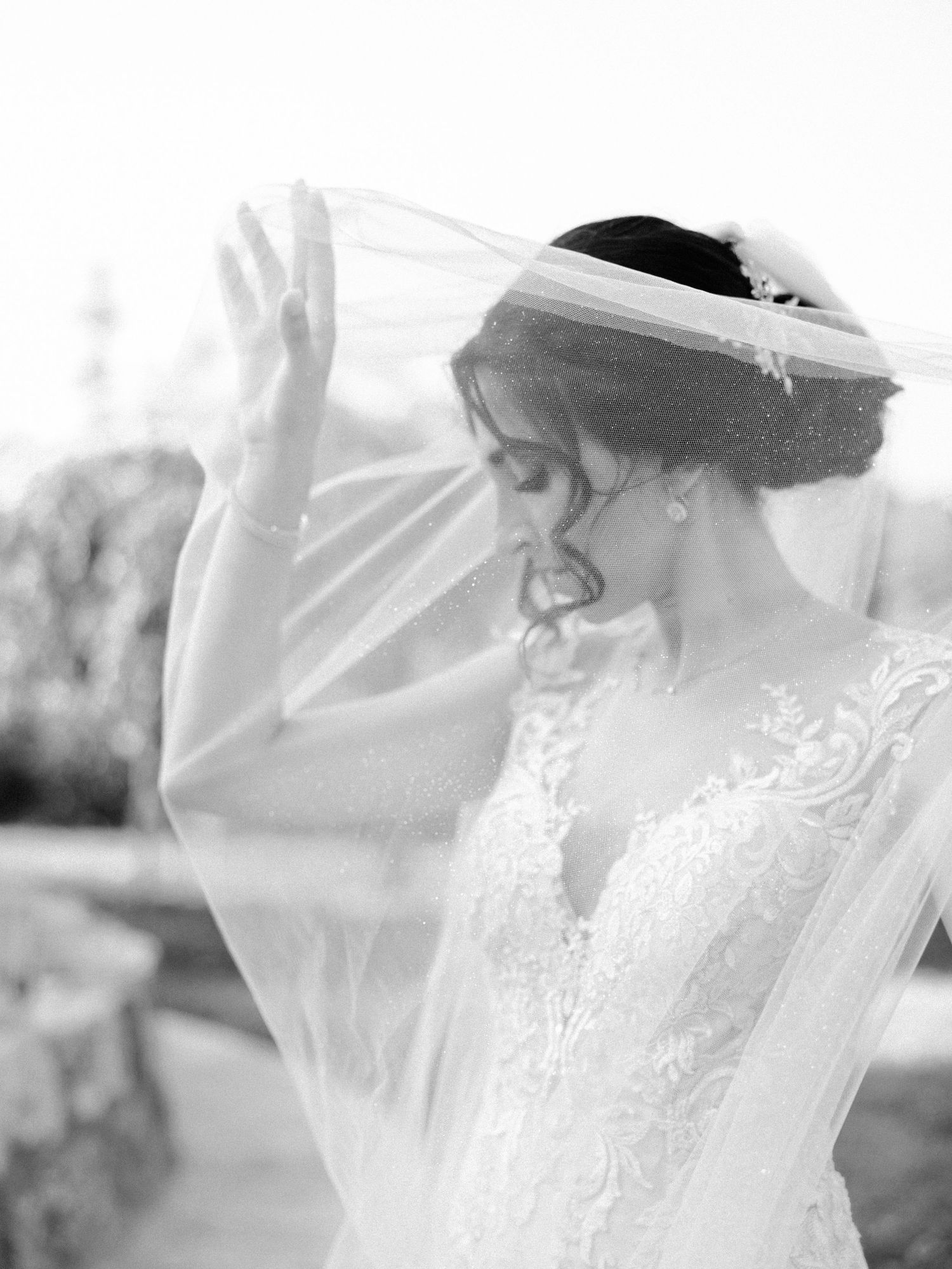 Ethereal black and white bridal portraits with flowing veil and lace details.