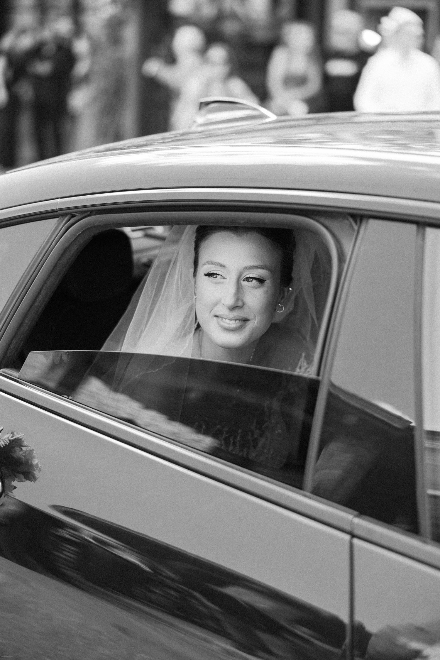Black and white photo series of a bride in a wedding car looking through the window.