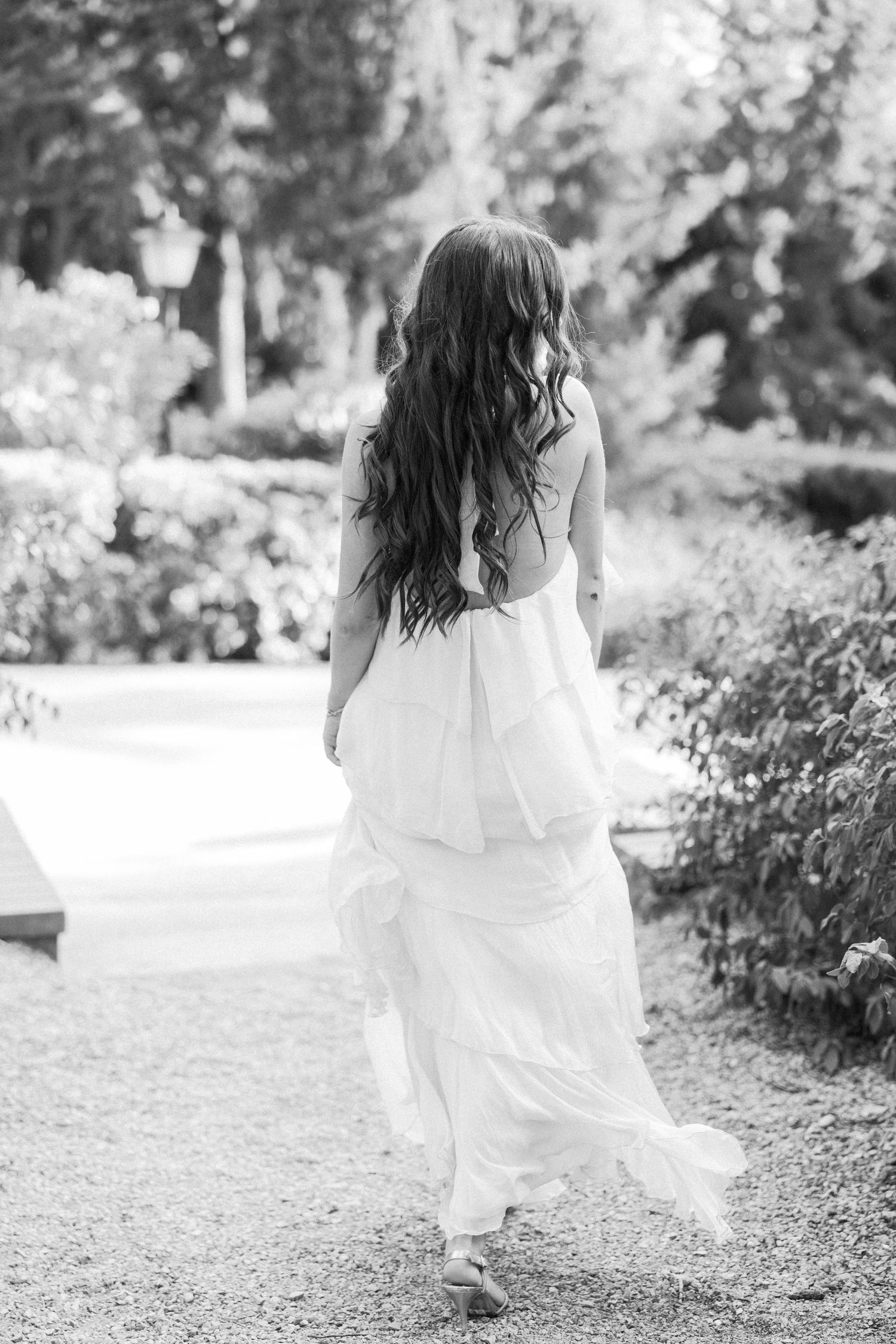 Ethereal shots of flowing white dress movement in an outdoor garden setting.
