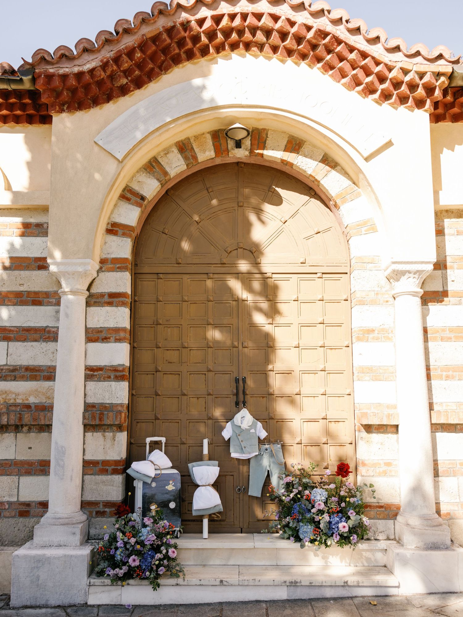 Decorative floral arrangements displayed beneath ornate stone arches with striped patterns in a historic gallery.