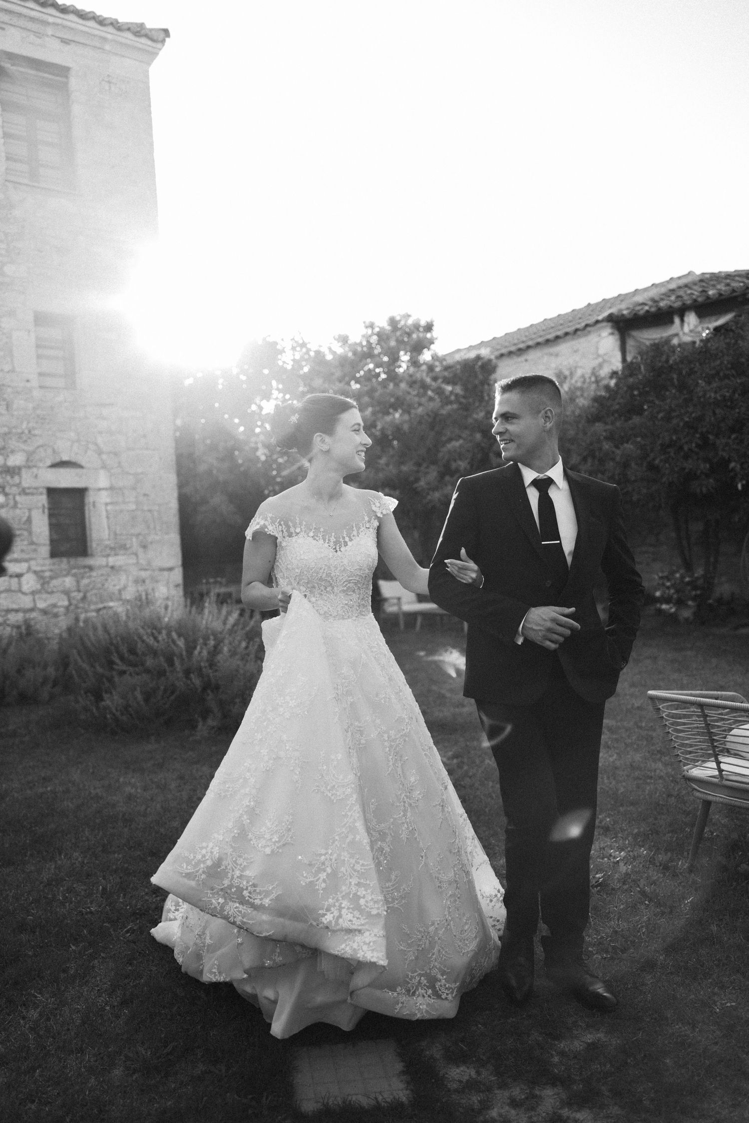 A couple dances together at sunset outside a stone building.