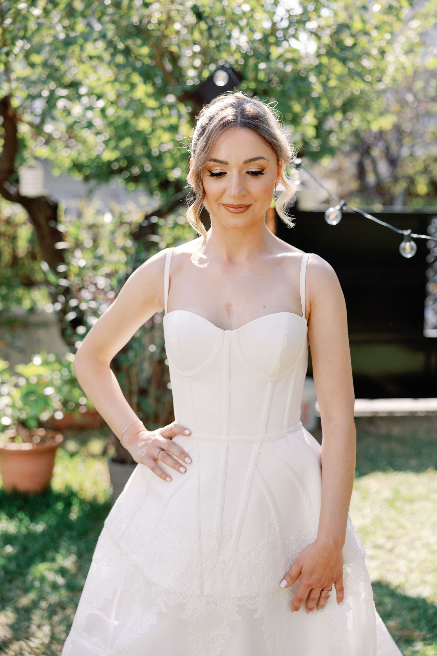 Close-up shots of a white wedding dress with delicate details in natural outdoor lighting.