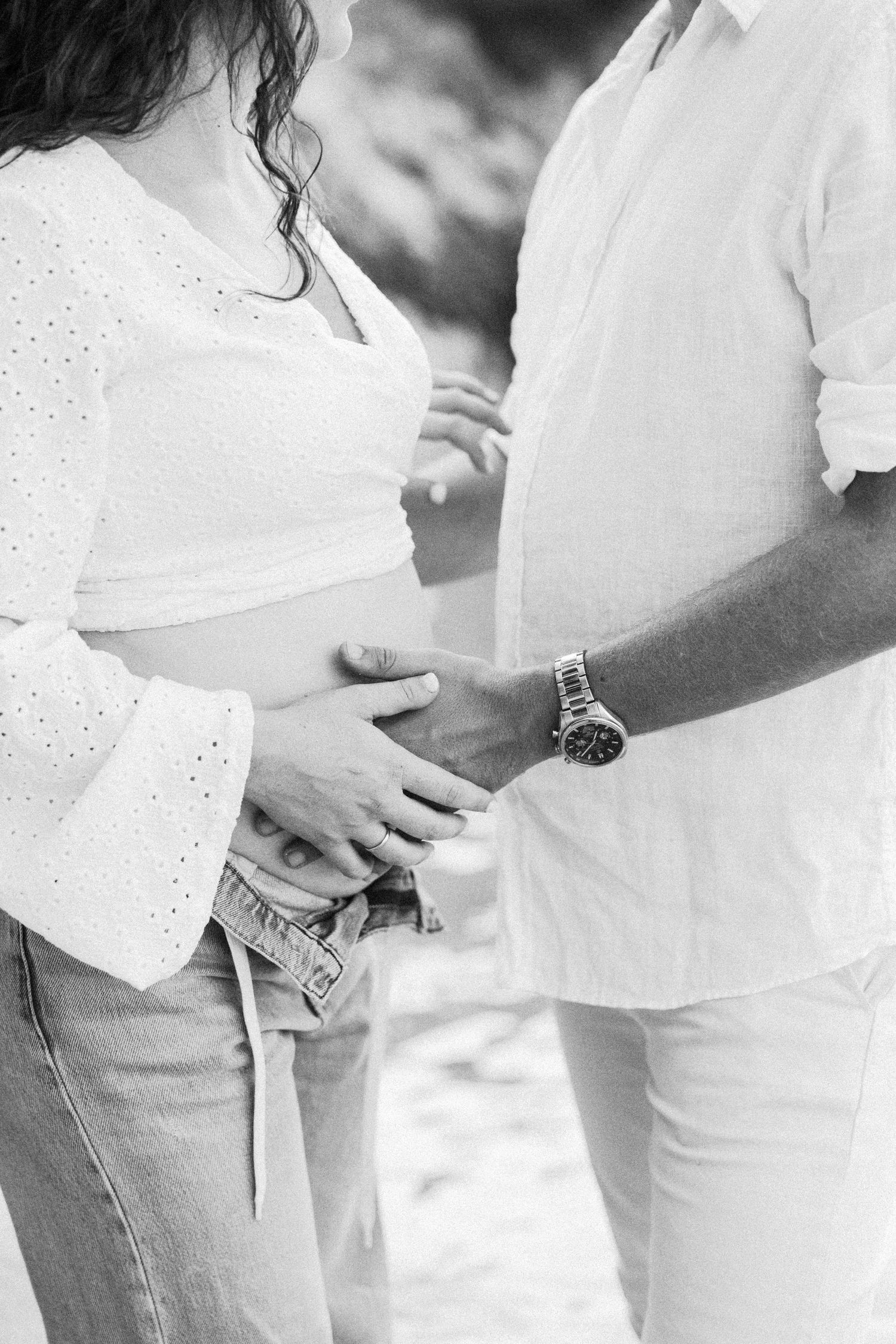 Black and white close-up of a couple in white clothing embracing tenderly.