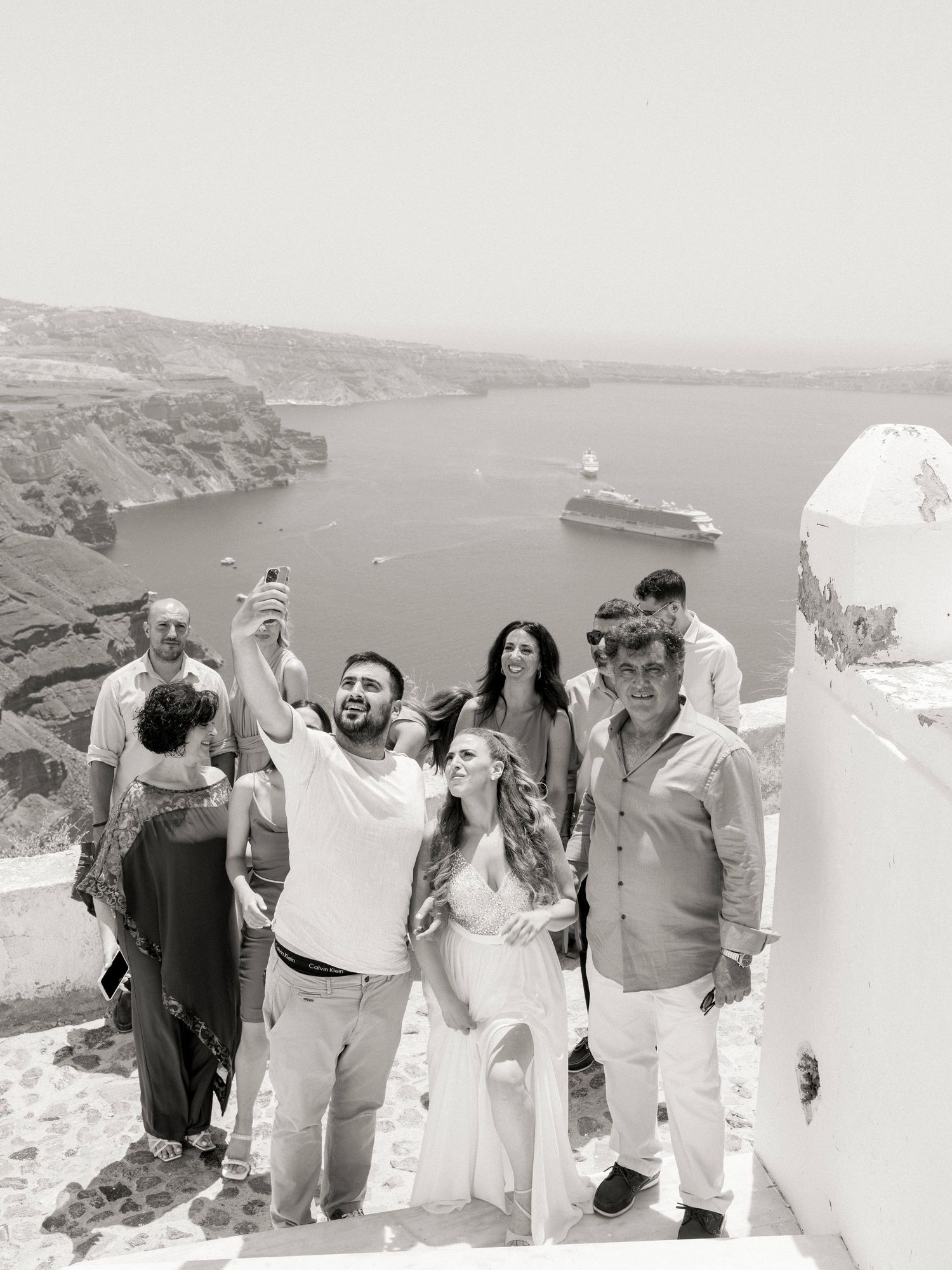 A group of people enjoying views from a scenic overlook in Santorini.