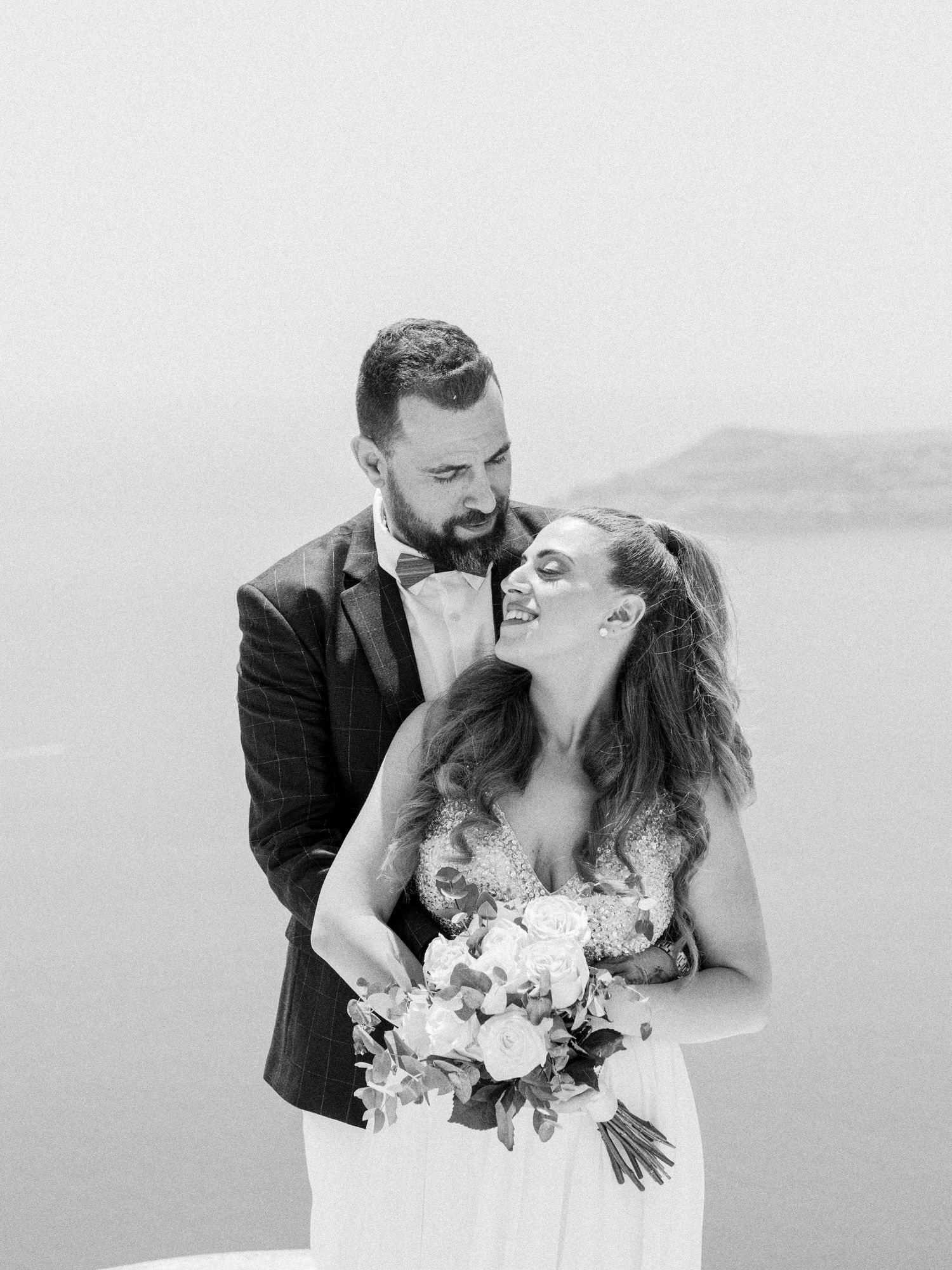 Black and white portrait of couple sharing intimate wedding moment.