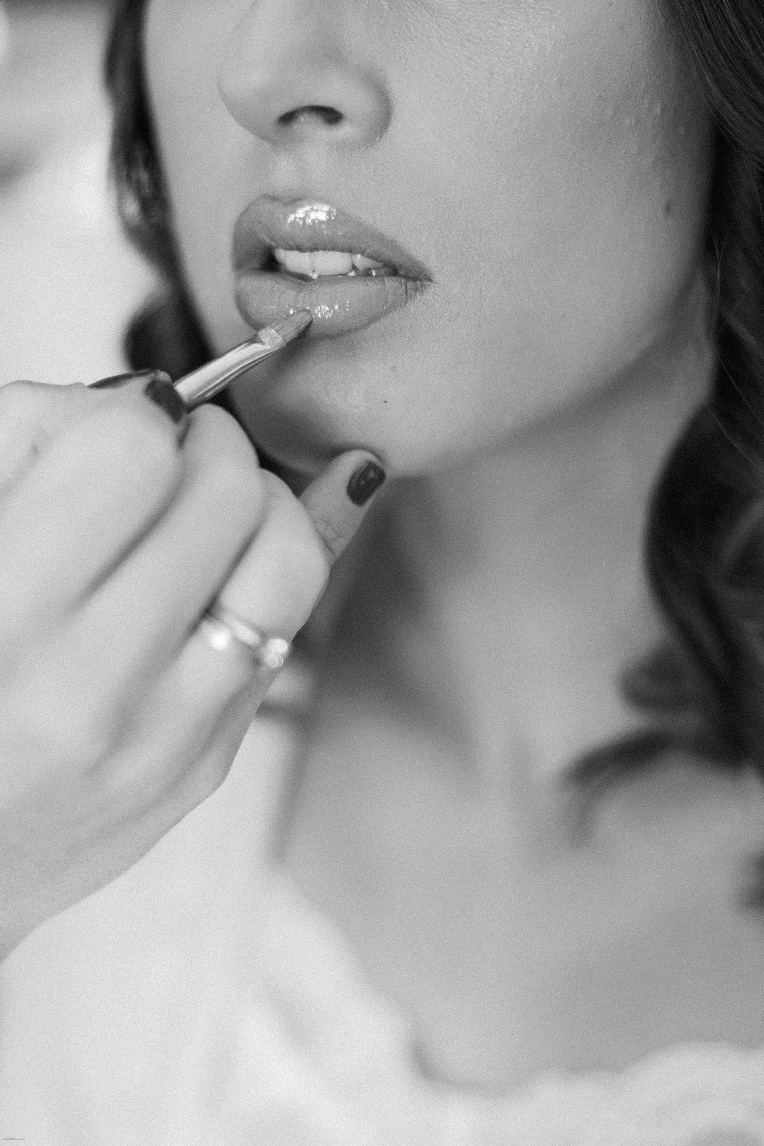 Close-up sequence of applying lipstick in black and white photography.