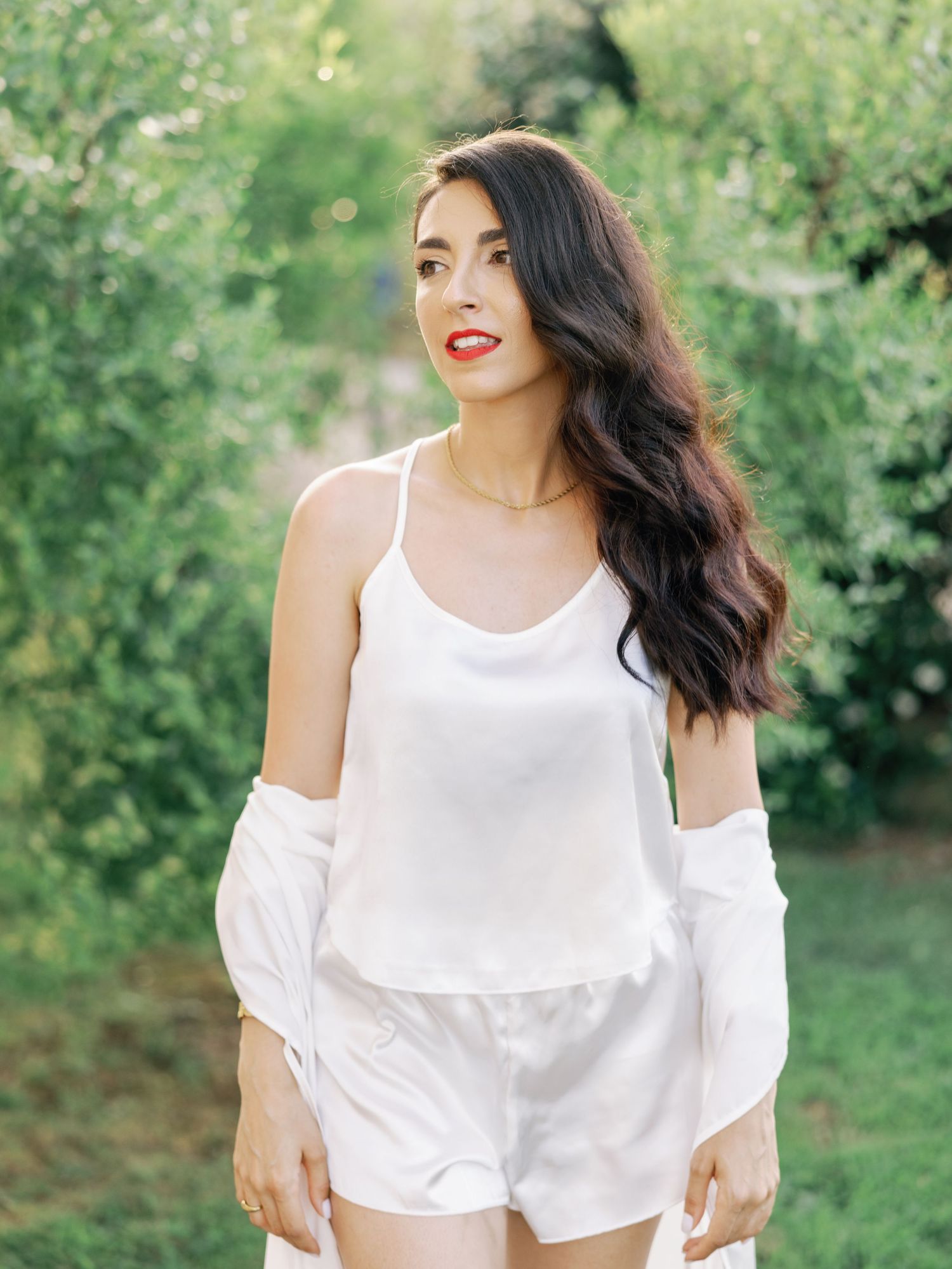 Summer garden portraits featuring white off-shoulder top against lush greenery.