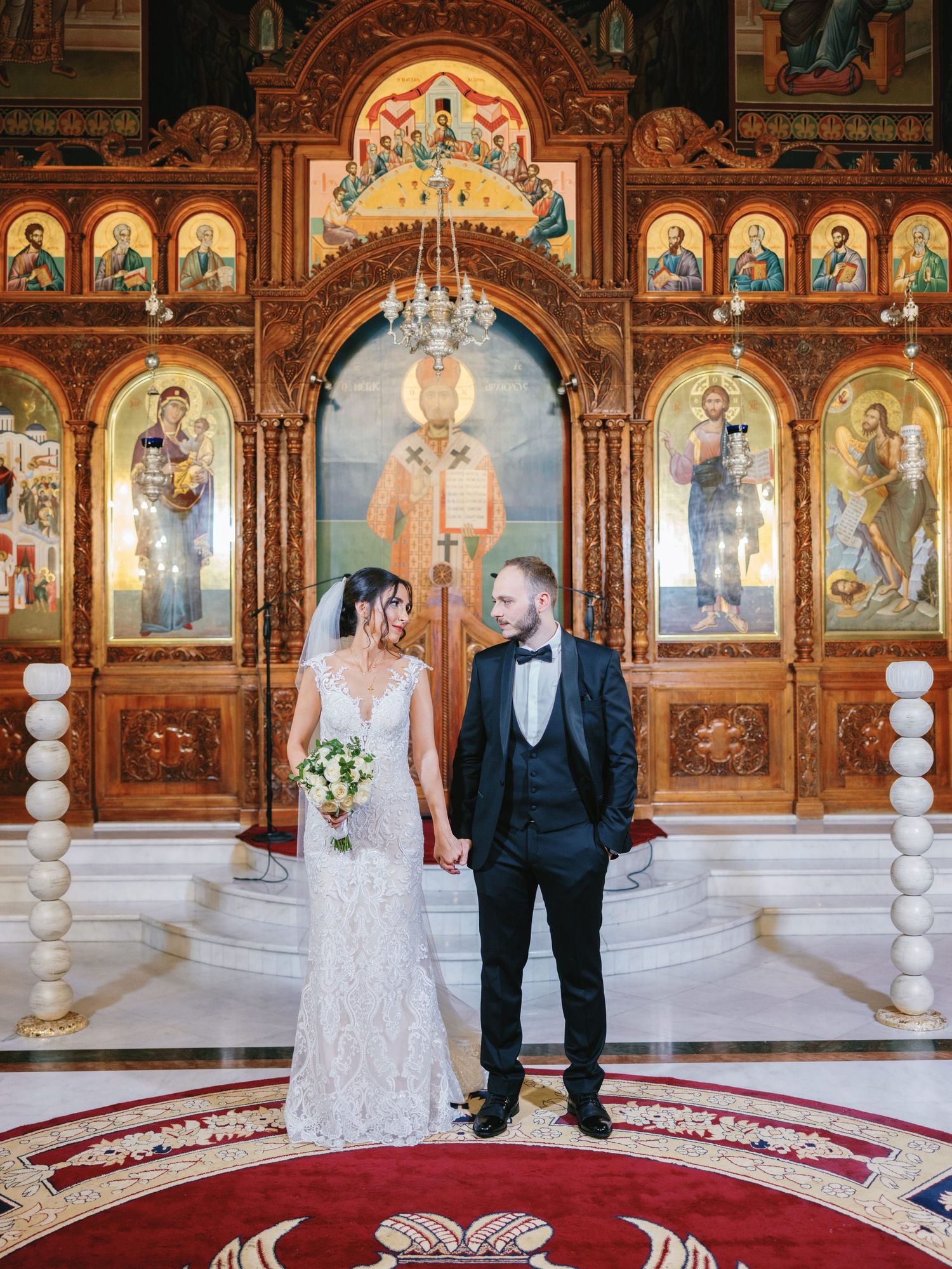 A wedding ceremony in a grand Orthodox church with detailed iconography and marble columns.
