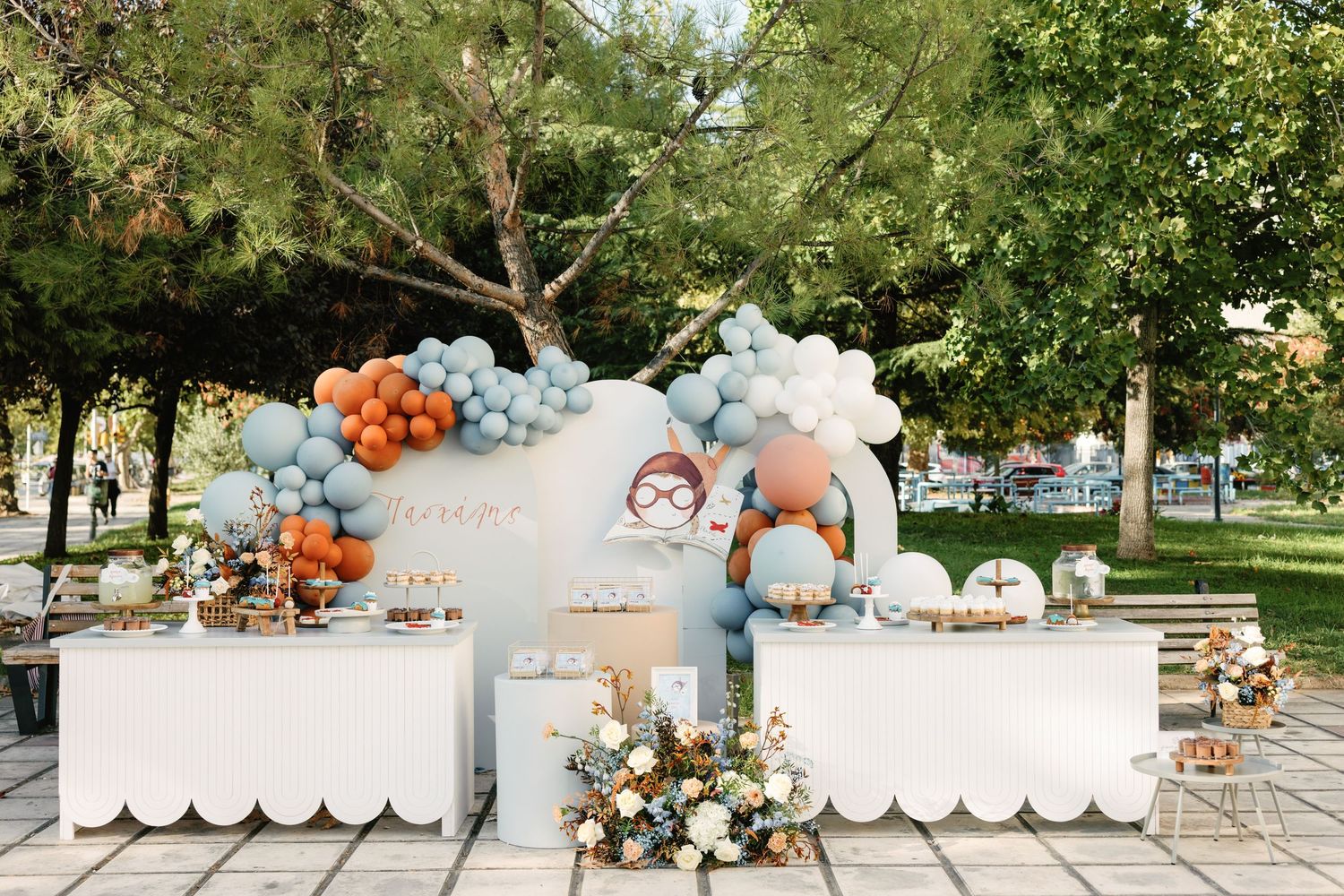A wedding ceremony setup in a garden with white chairs, floral arrangements, and pumpkin decorations for a fall celebration.