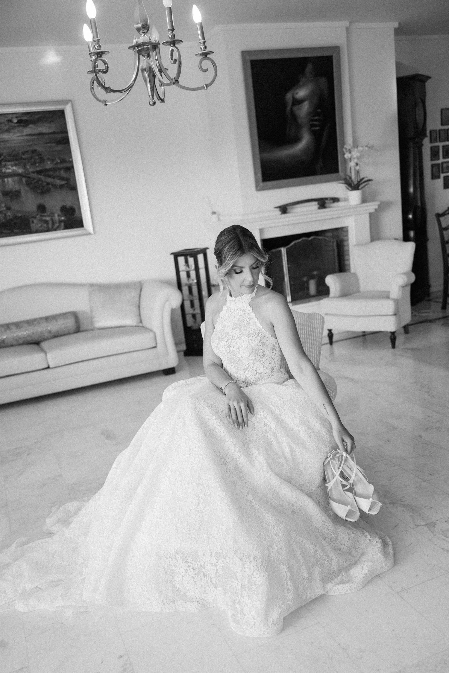 Artistic black and white photo of bride reclining in her ballgown on marble floors.