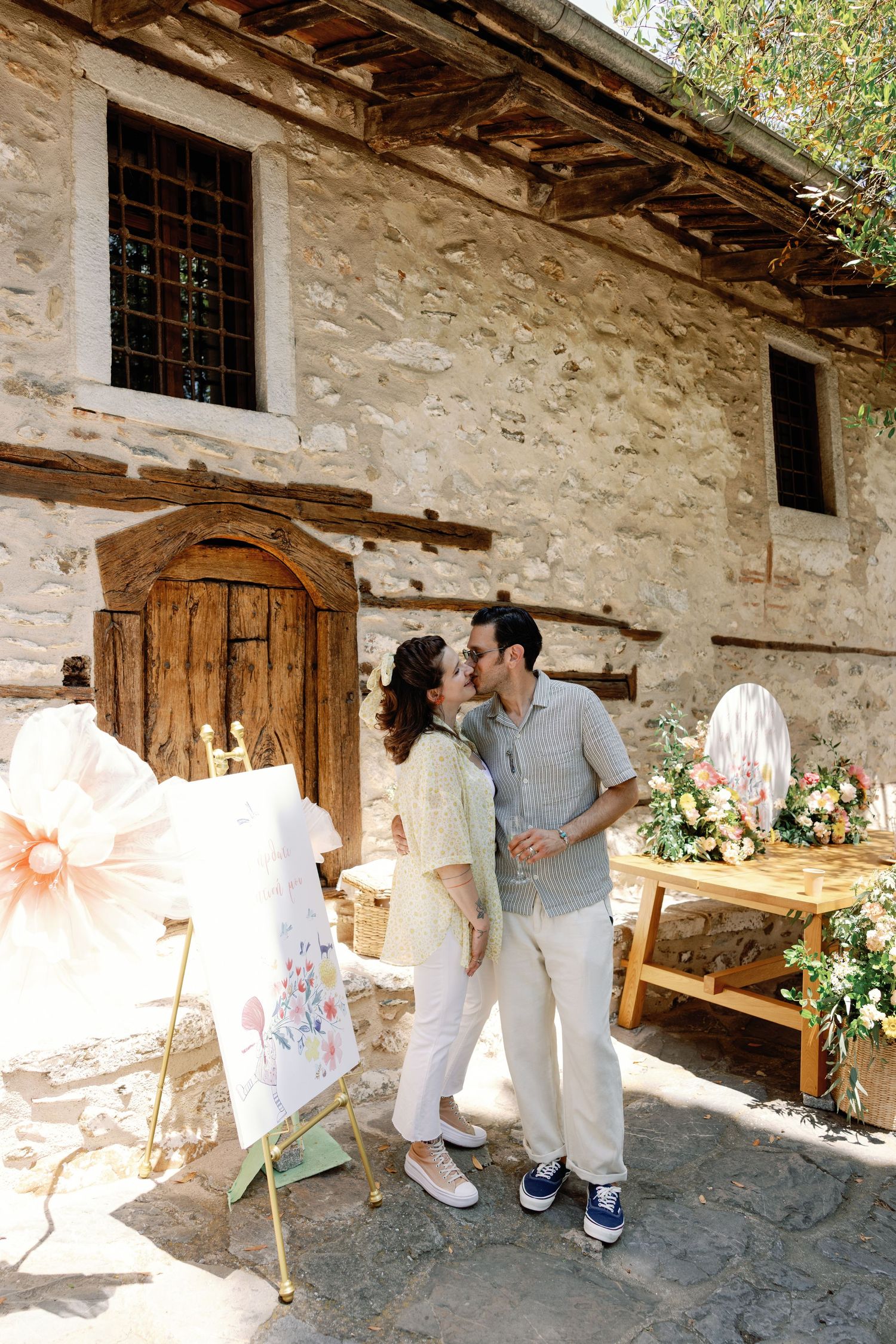 Romantic photoshoot in a rustic stone building with floral decorations and white fabric.