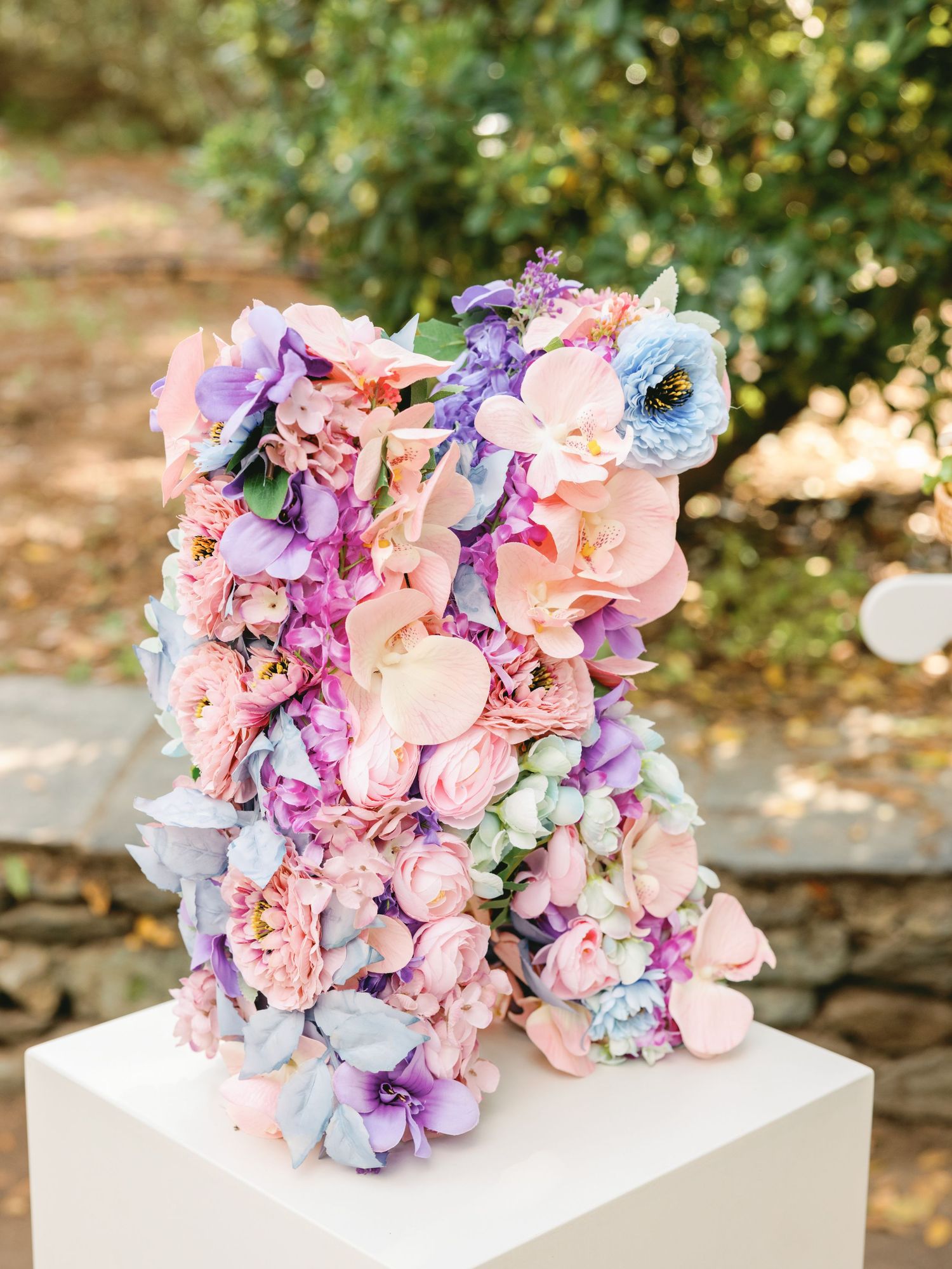 Close-up of delicate pink and purple hydrangea flowers arranged in a decorative bouquet on a white surface.