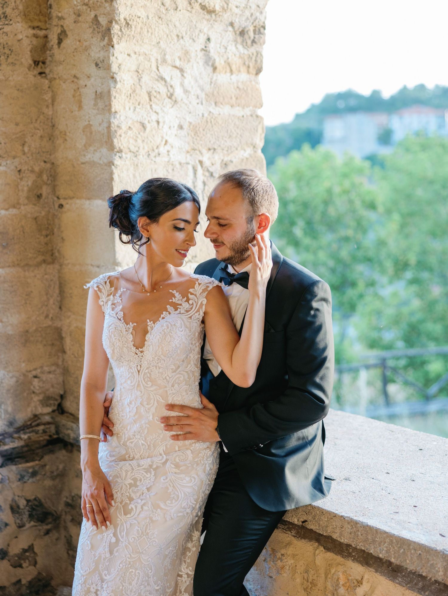 Romantic wedding portraits captured in a rustic stone colonnade setting.