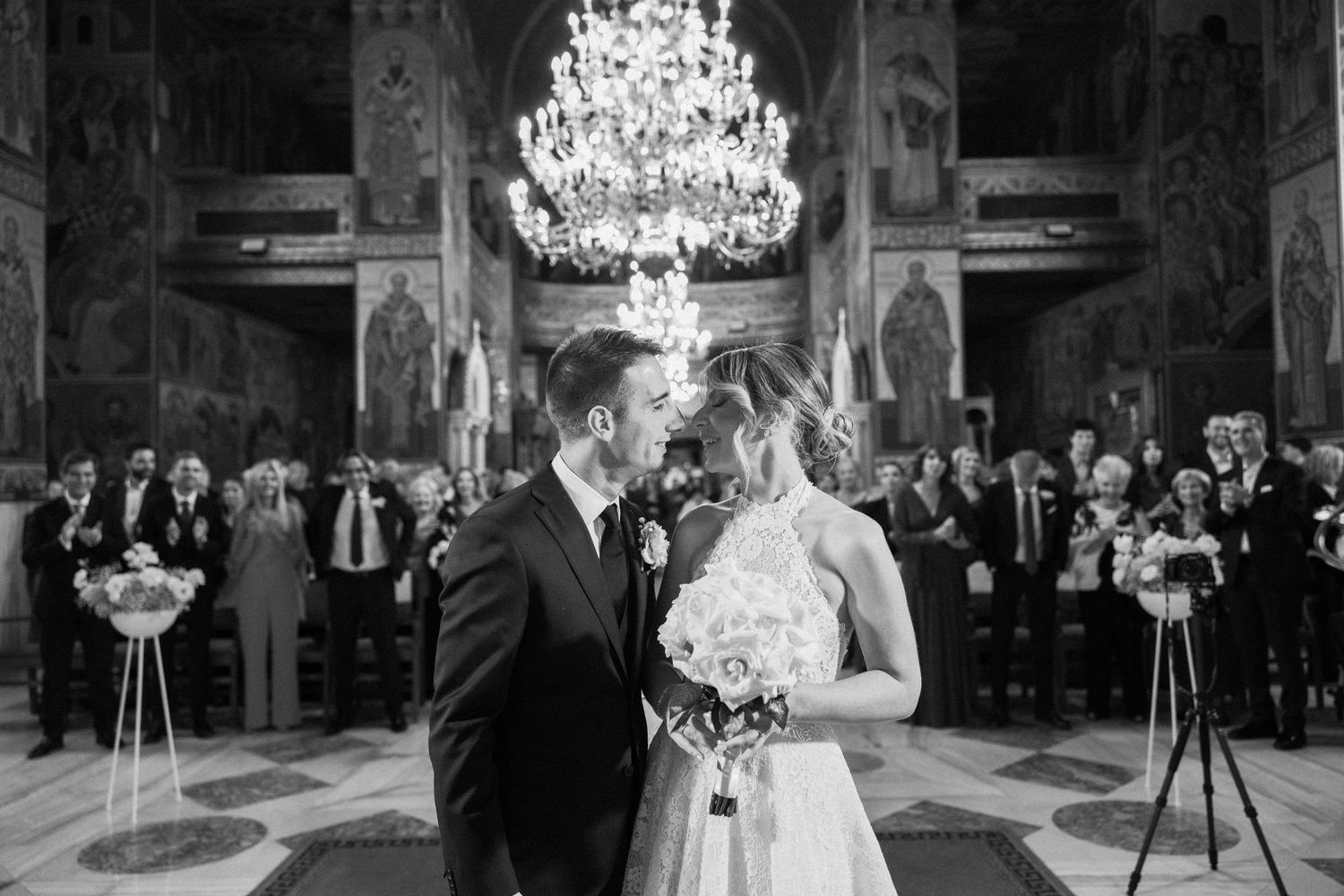 Wedding reception in elegant ballroom with crystal chandeliers and dancing guests.