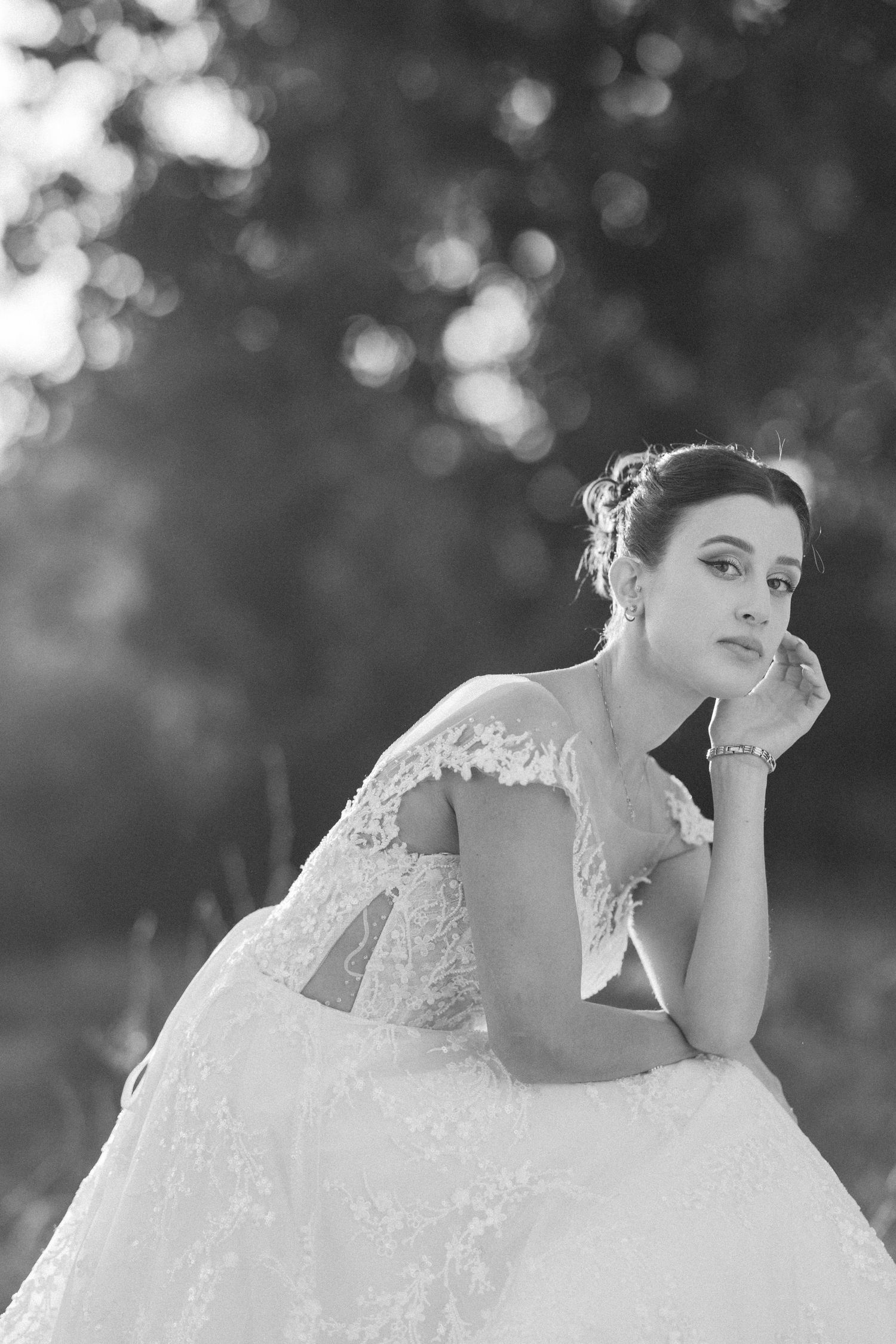 Black and white portrait of a bride in a romantic outdoor setting.
