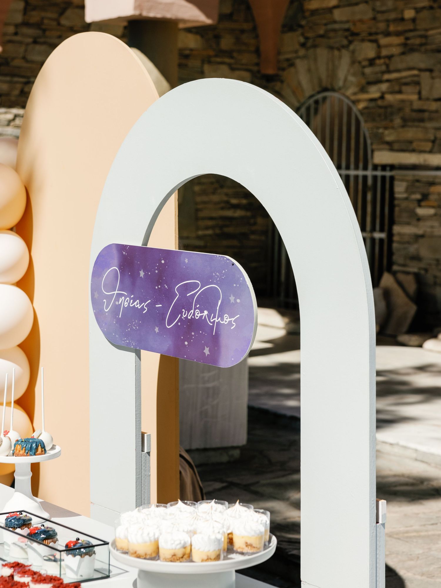 White arched wedding decor displays with purple accents and floral arrangements create an elegant ceremony backdrop.
