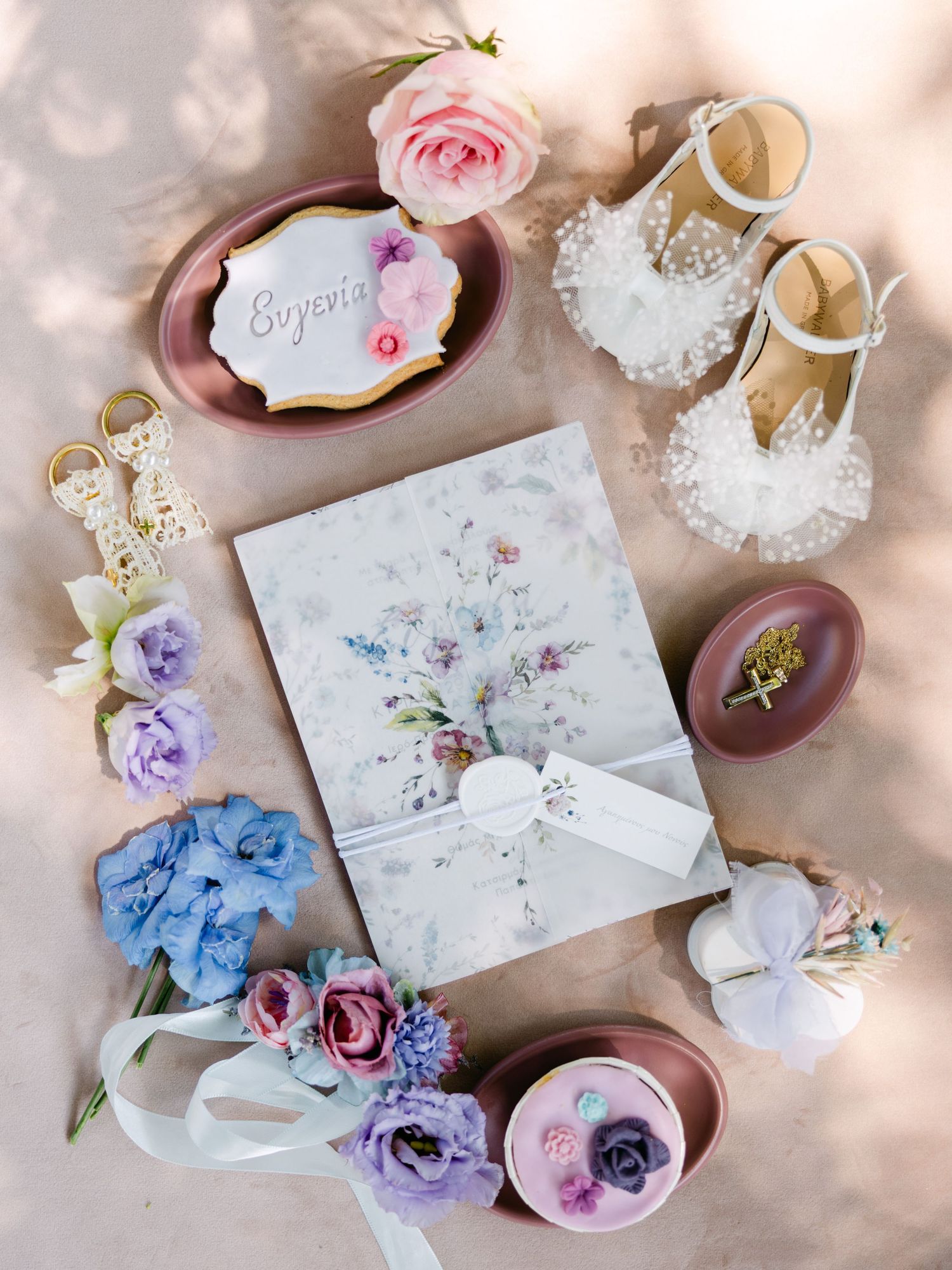 Elegant wedding details including delicate floral arrangements, invitations, and accessories in soft pink and purple tones.
